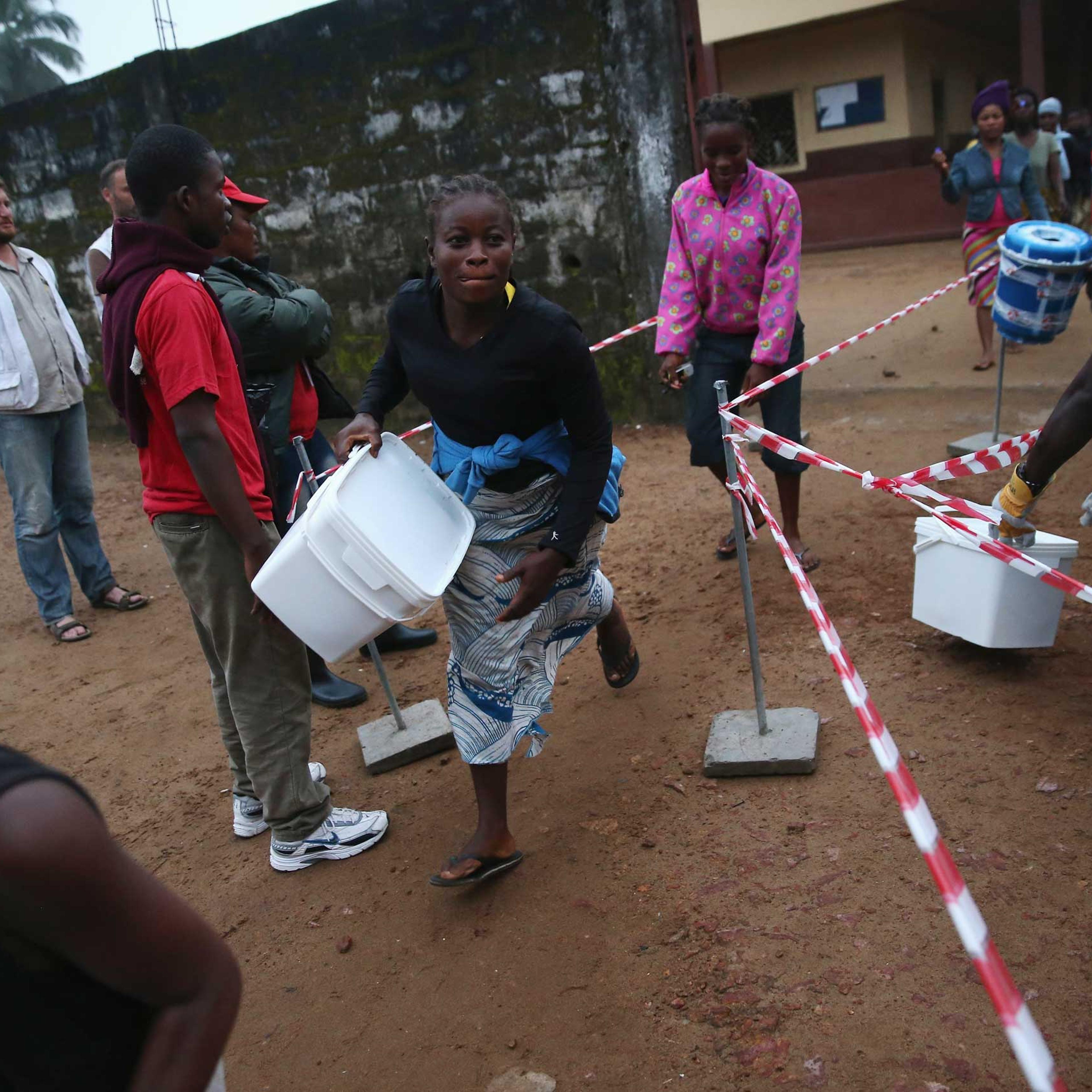 Residents take home family and home disinfection kits distributed by Doctors Without Borders, on Oct. 4, 2014 in New Kru Town, Liberia.
