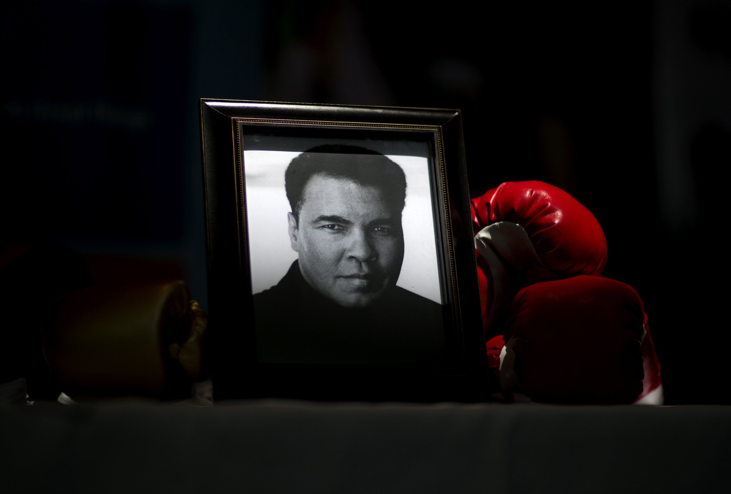 A portrait of Muhammad Ali is displayed next to a pair of boxing gloves at the I Am Ali Festival at the Kentucky Center for the Performing Arts, in Louisville, June 8, 2016.
