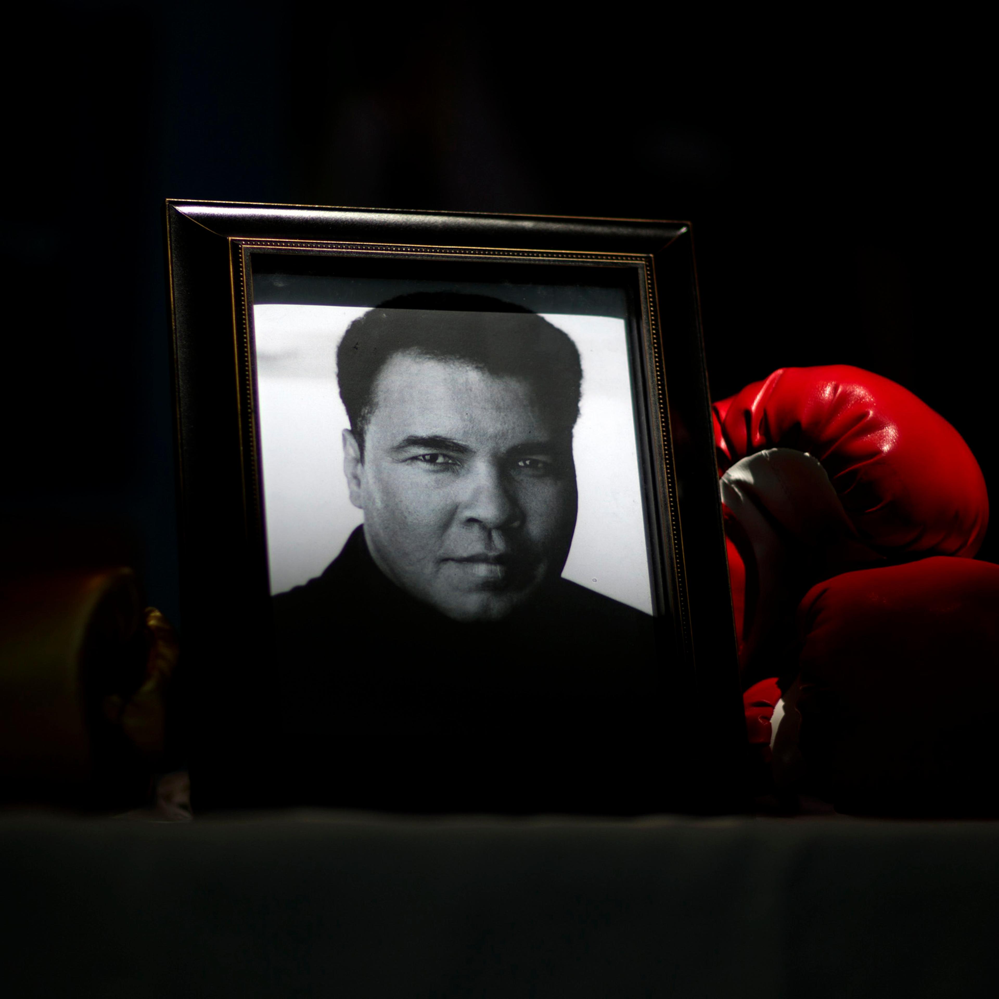 A portrait of Muhammad Ali is displayed next to a pair of boxing gloves at the I Am Ali Festival at the Kentucky Center for the Performing Arts, in Louisville, June 8, 2016.