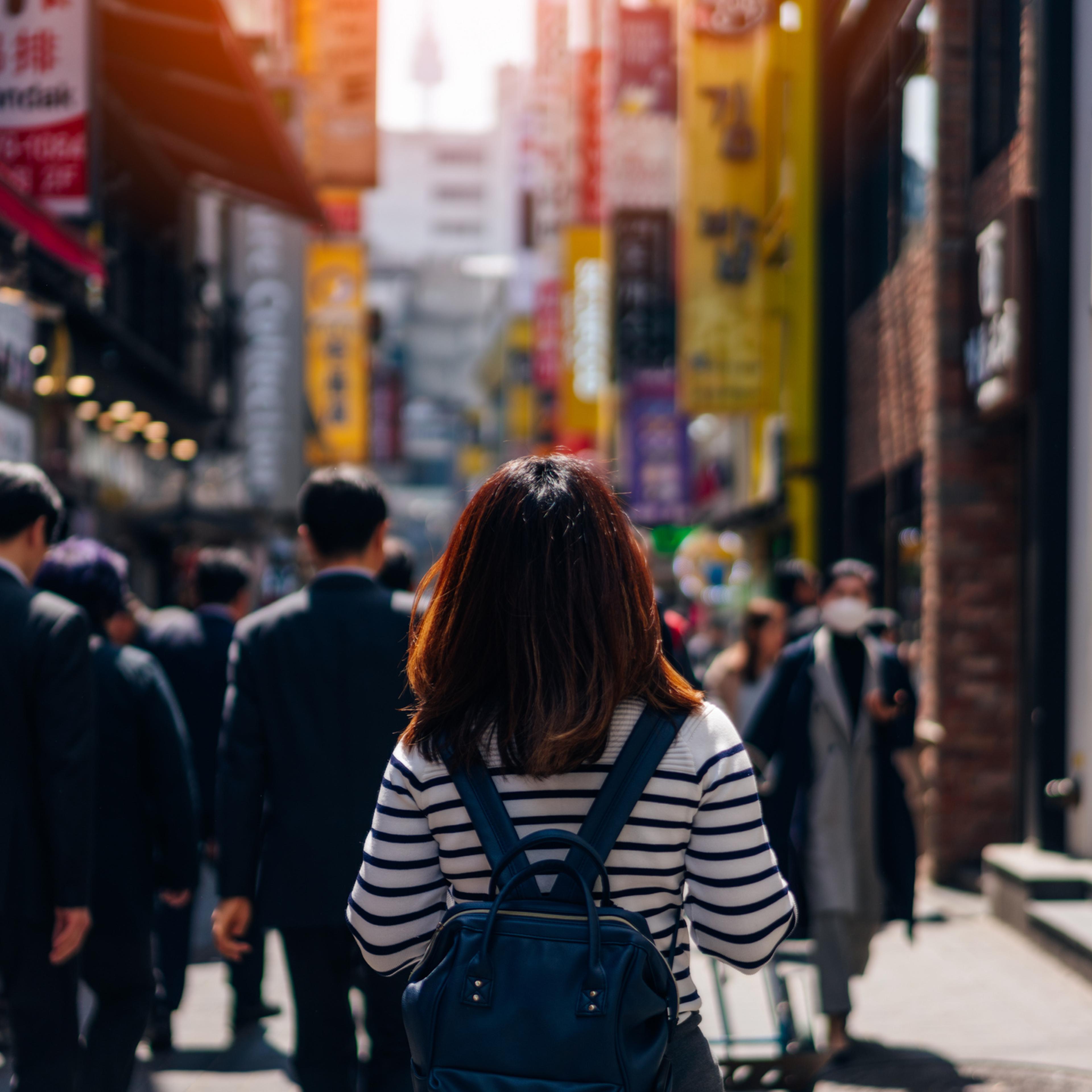 Young asian woman traveler traveling and shopping in Myeongdong street market at Seoul, South Korea. Myeong Dong district is the most popular shopping market at Seoul city.