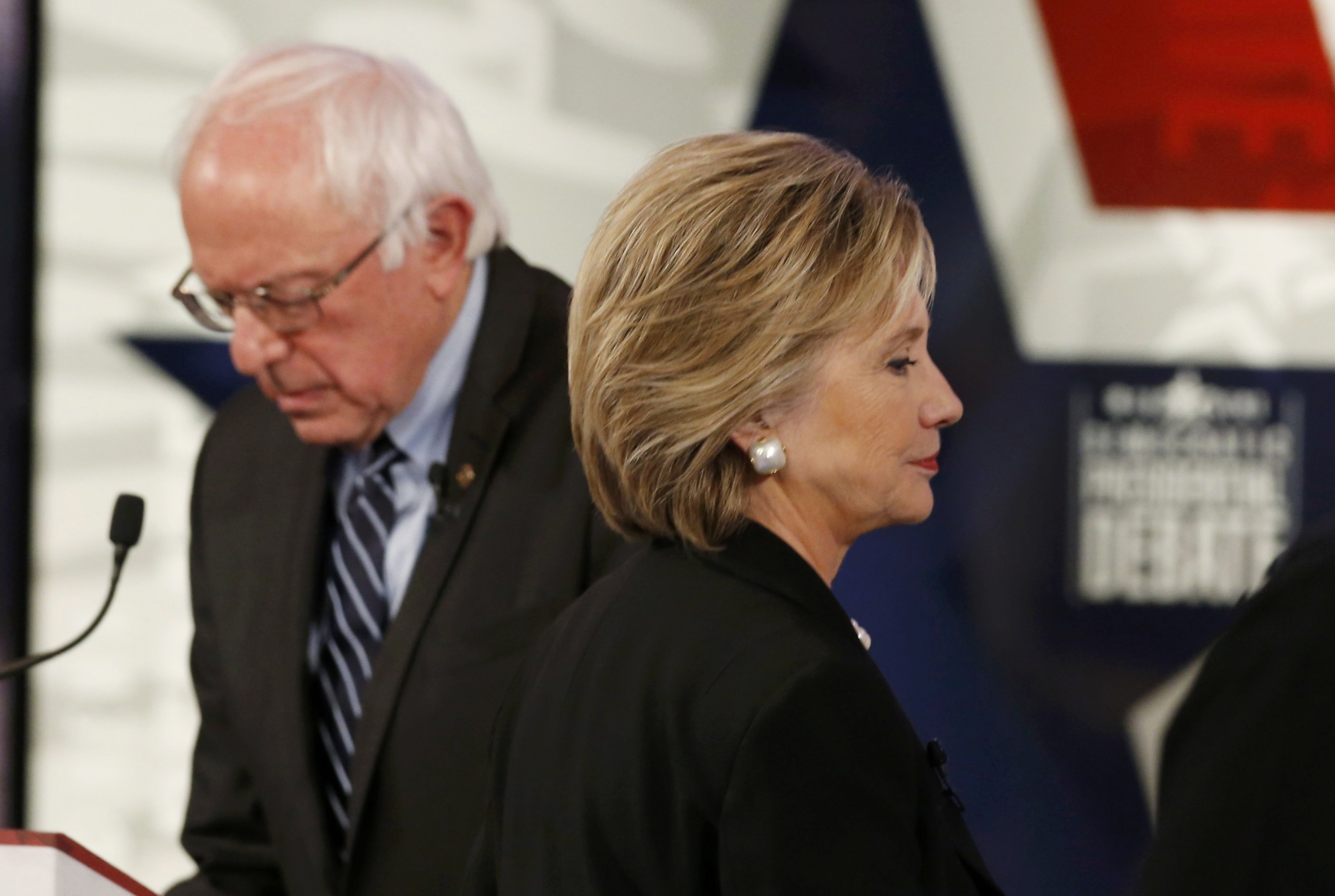 Democratic U.S. presidential candidate Clinton walks past Sanders during a break at the second official 2016 U.S. Democratic presidential candidates debate in Des Moines