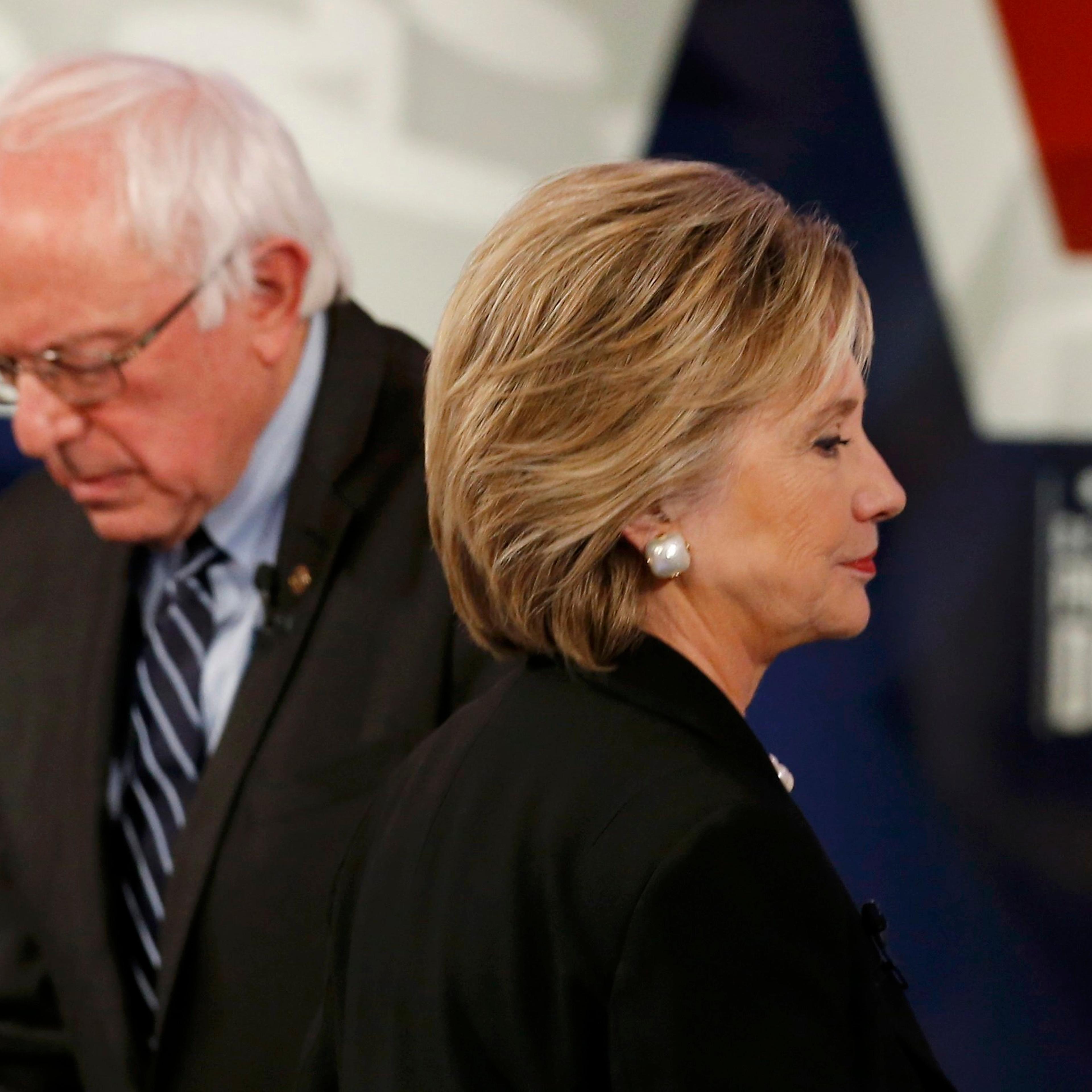 Democratic U.S. presidential candidate Clinton walks past Sanders during a break at the second official 2016 U.S. Democratic presidential candidates debate in Des Moines