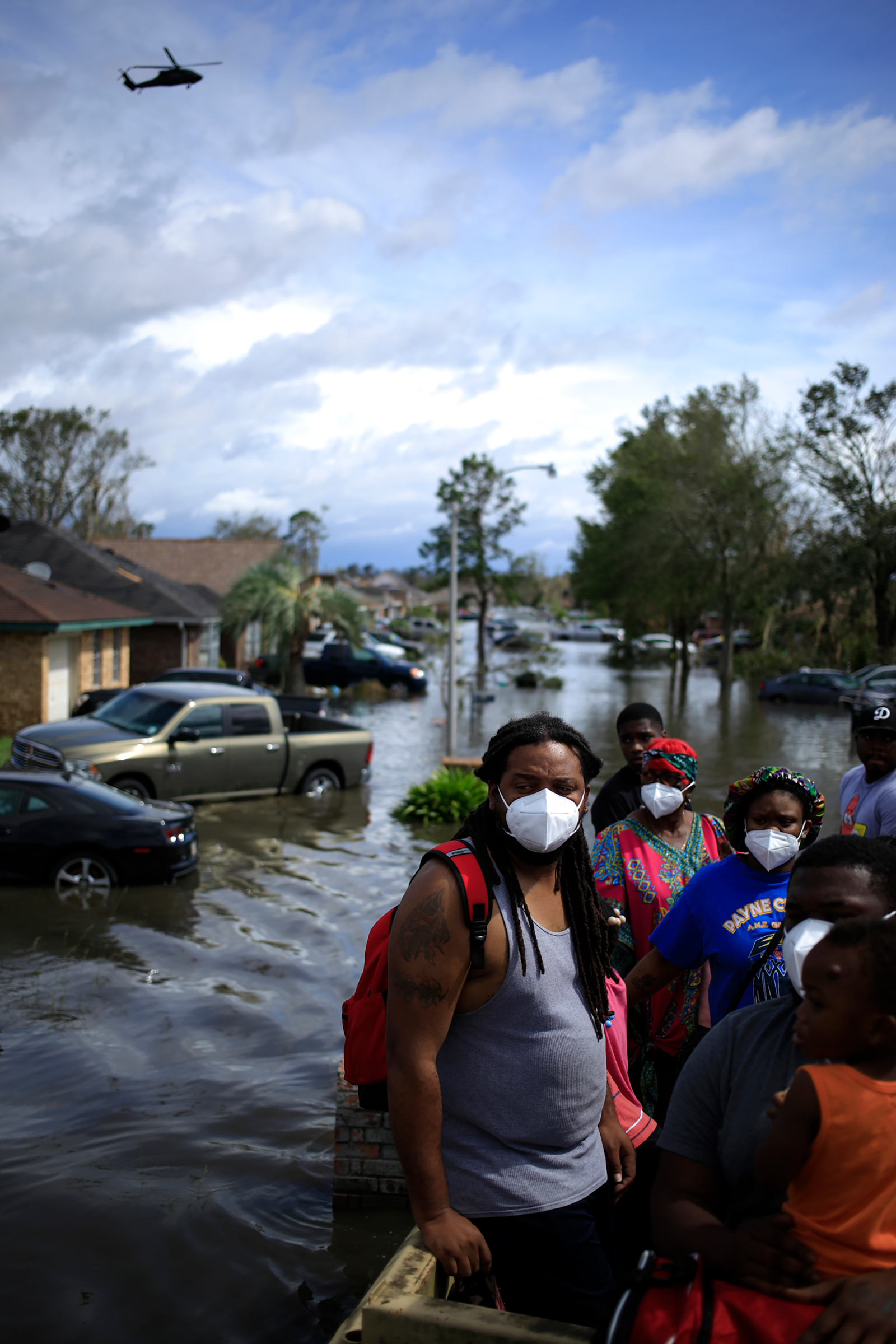 Residents ride in a high water vehicle after being rescued from floodwater left behind by Hurricane Ida in LaPlace, La. on Aug. 30.