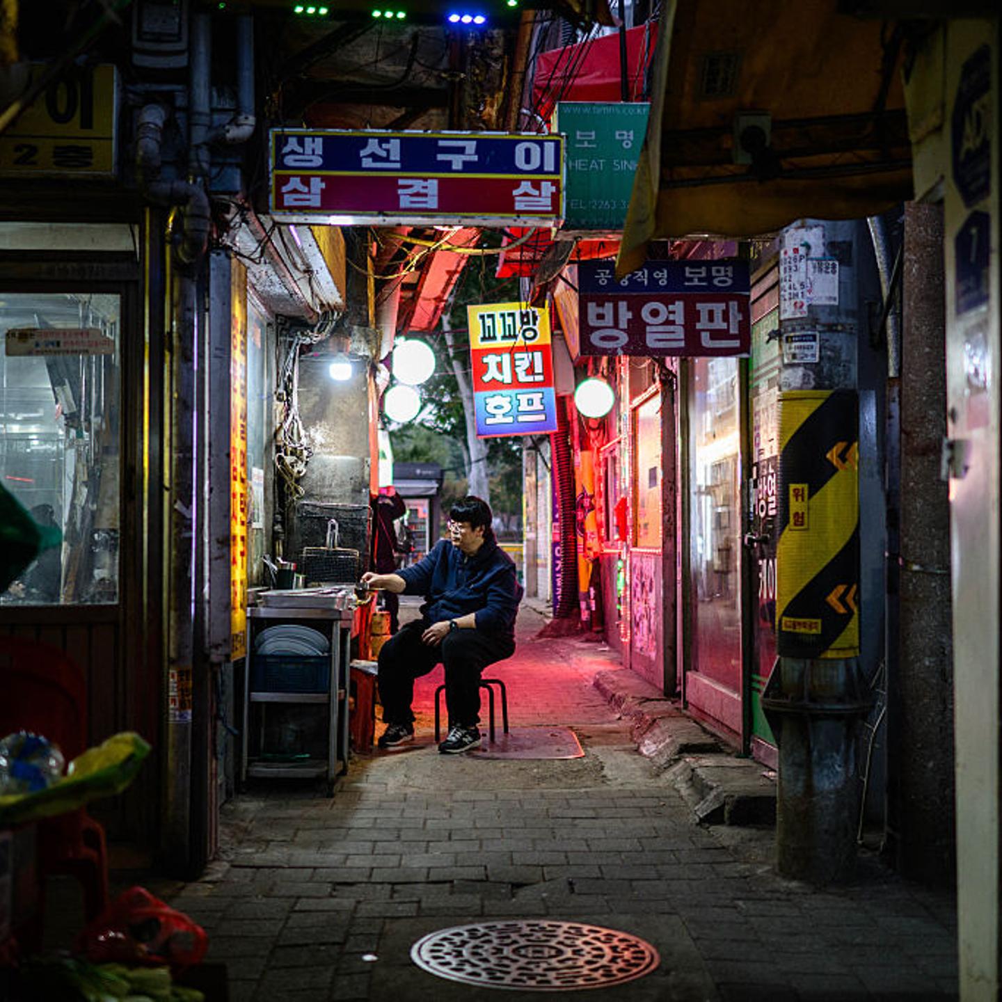 A cook waits for customers outside a restaurant in Seoul, South Korea, on Nov. 5, 2025.