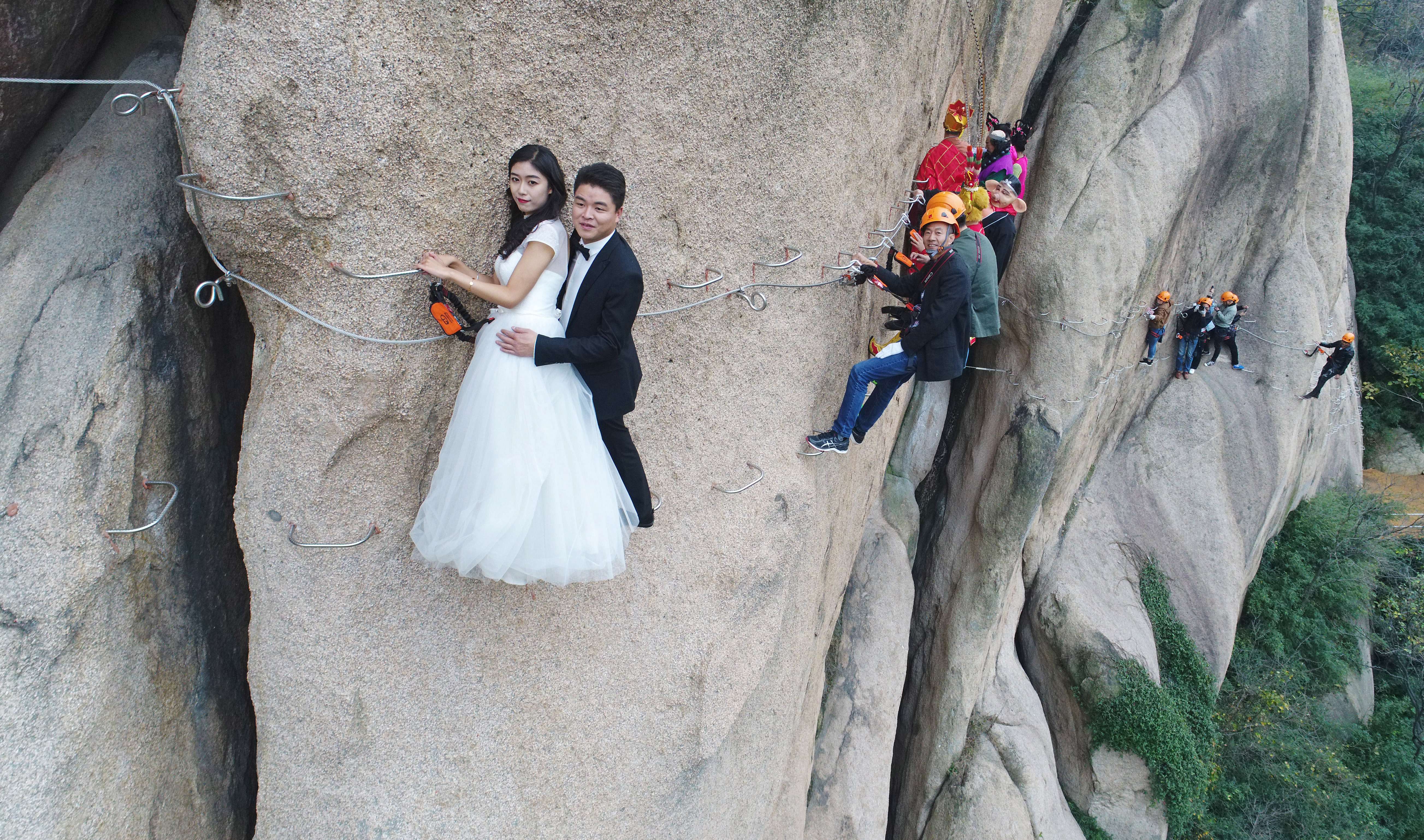 Newlywed Couple Poses For Wedding Photos On Cliff Face In Zhumadian