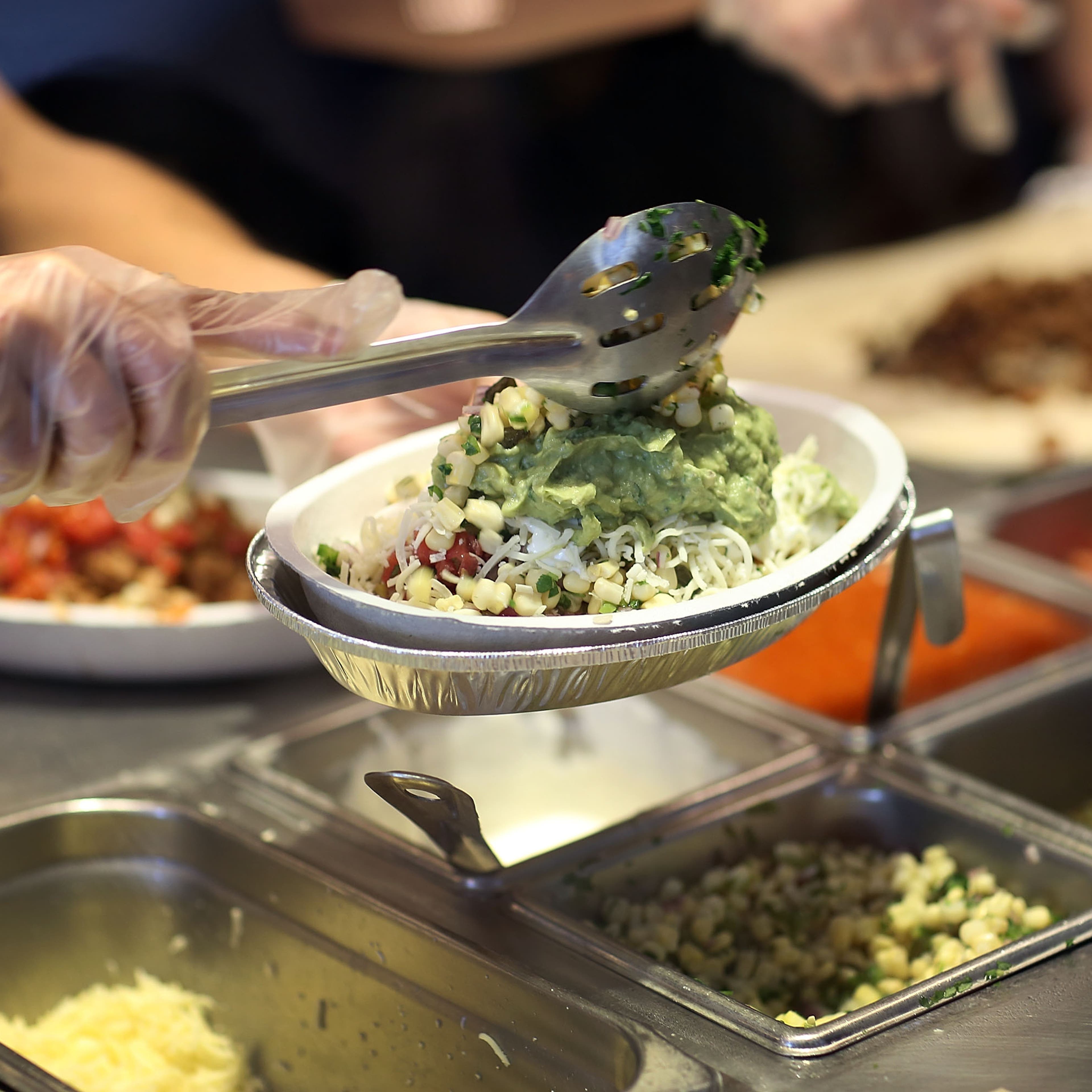 Chipotle restaurant workers fill orders for customers on the day that the company announced it will only use non-GMO ingredients in its food on April 27, 2015 in Miami, Florida.