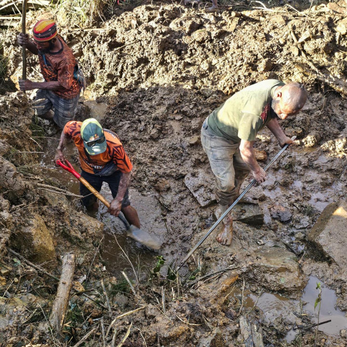 People dig through debris at the site of a landslide in Yambali village in the region of Maip Mulitaka, in Enga Province, Papua New Guinea.
