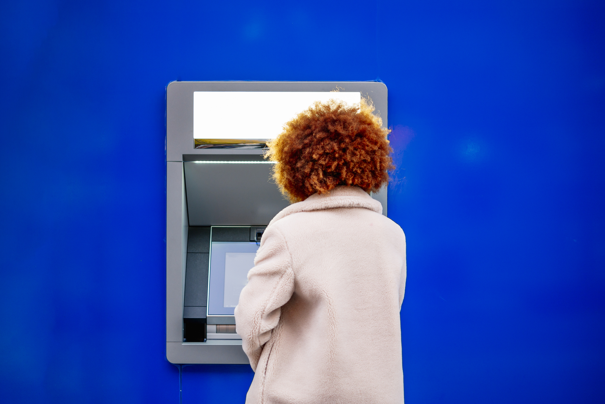 Mid adult woman with afro hair using kiosk in city