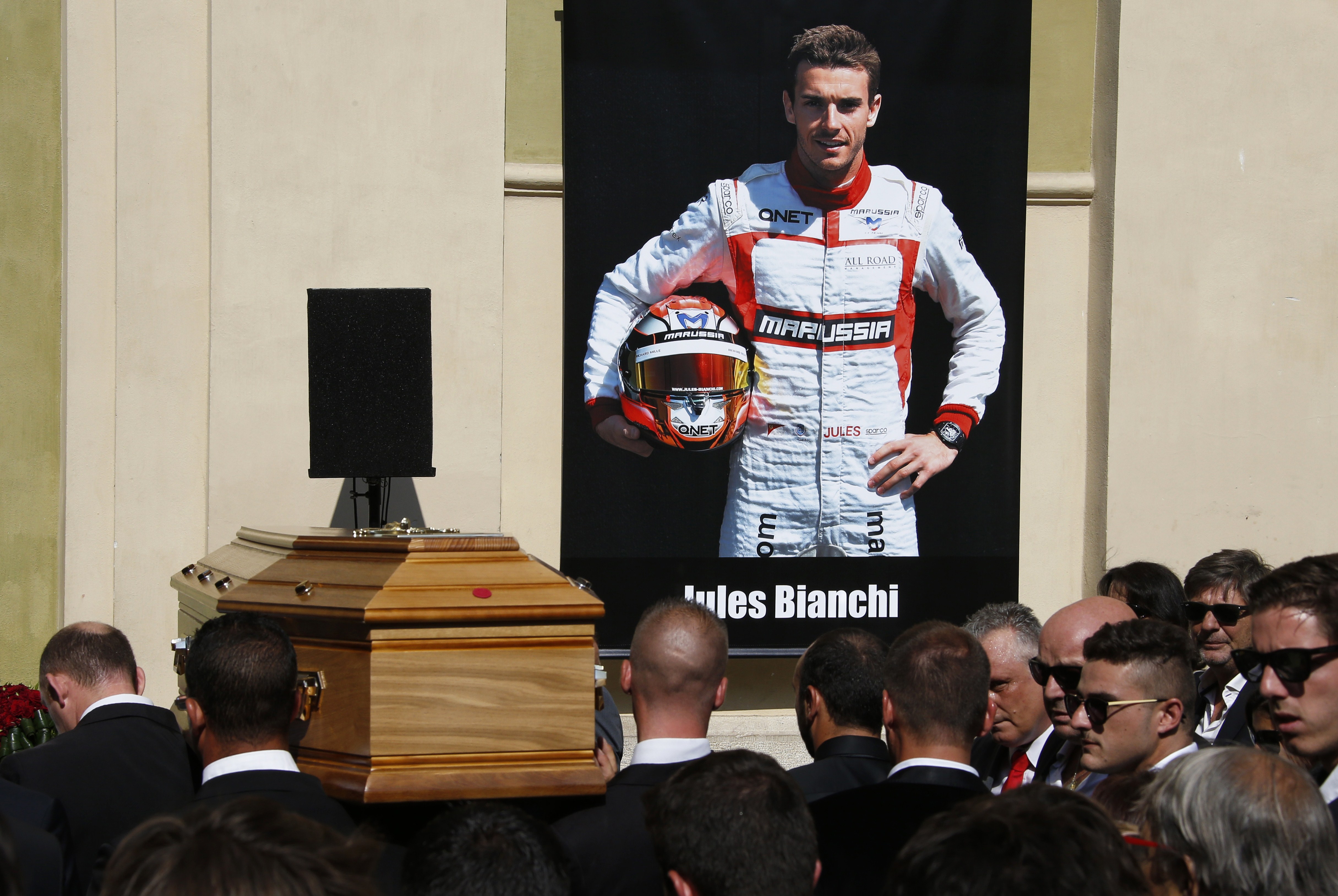 Pallbearers carry the coffin of French Formula One driver Jules Bianchi past a portrait of him during his funeral ceremony at the Cathedrale Sainte Reparate in Nice, southeastern France, on July 21, 2015.