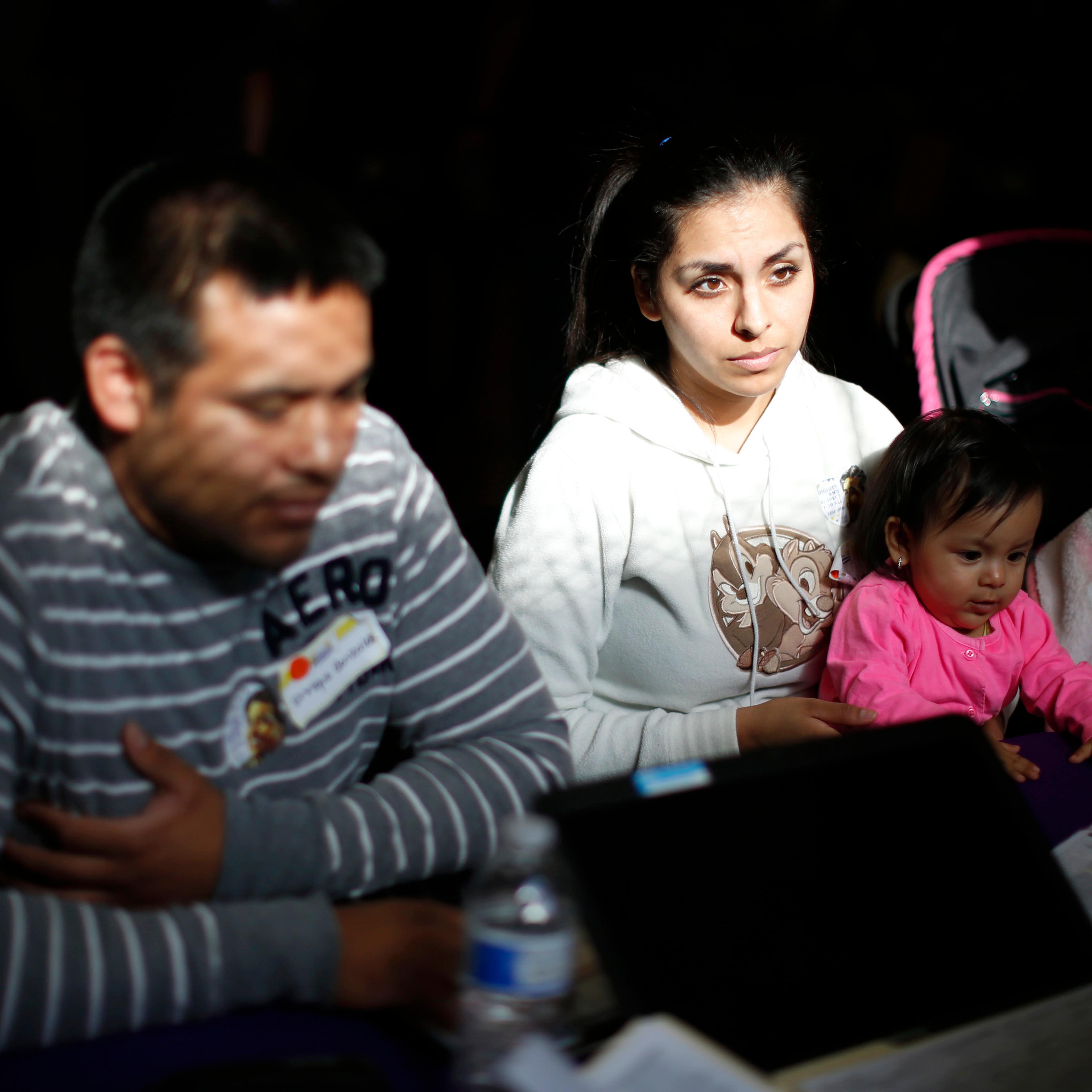 From left: Enrique Gonzalez, 22, Janet Regalado, 21, and their nine-month-old daughter Kayleen Gonzalez sign up for health insurance at an enrolment event in Commerce, Calif., on March 31, 2014.