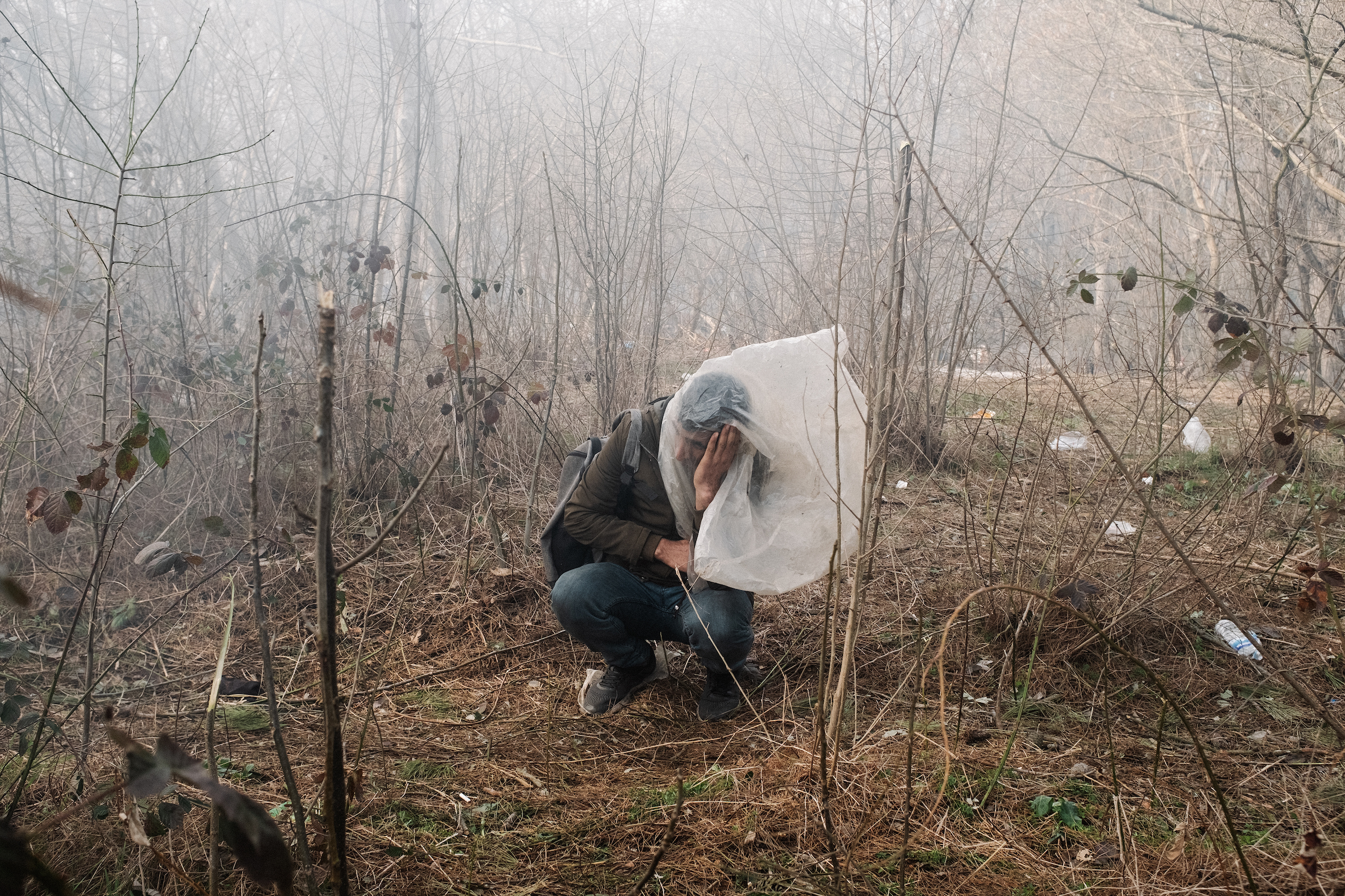 A man desperately tries to protect himself from tear gas launched by Greek authorities on the border with Turkey.