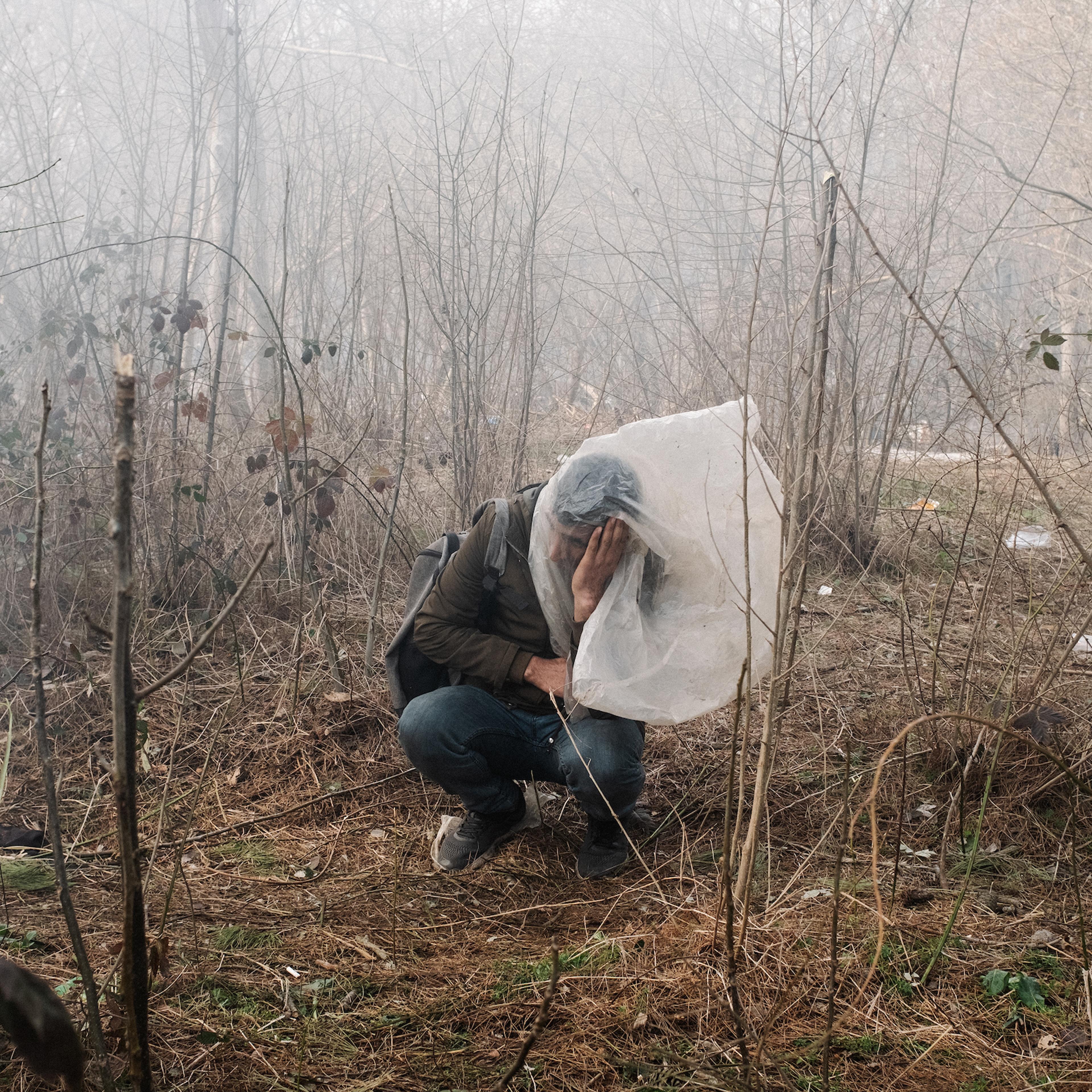 A man desperately tries to protect himself from tear gas launched by Greek authorities on the border with Turkey.