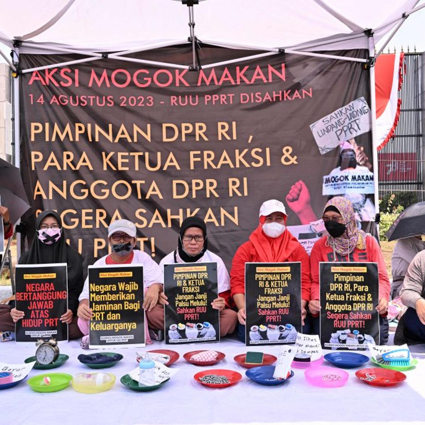 Activists take part in a hunger strike outside the Indonesian parliament building in Jakarta on Aug. 14, 2023, as part of a protest demanding MPs to pass a bill protecting domestic workers.