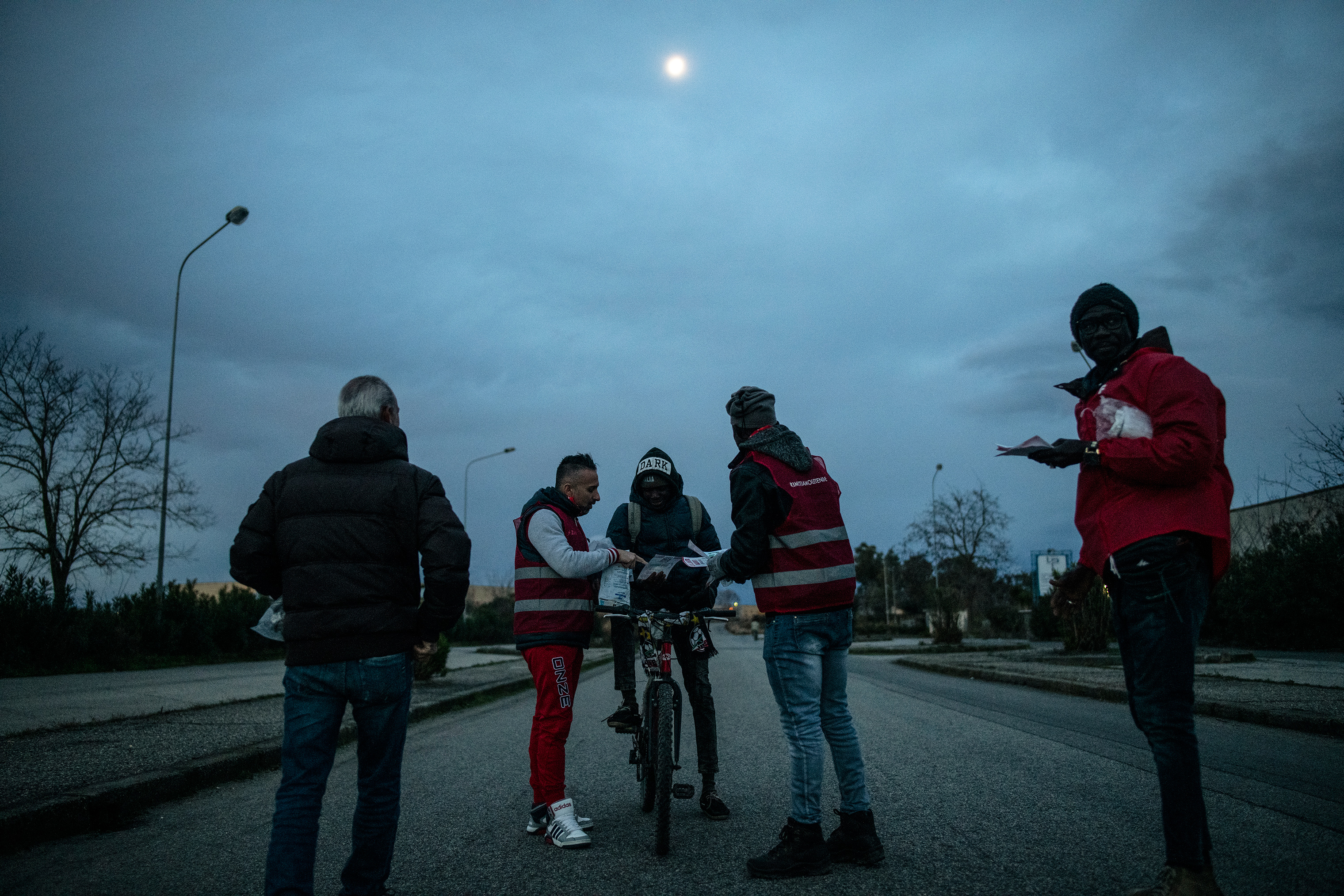 Migrant workers receive educational pamphlets about their rights in Italy, Jan. 24, 2019.