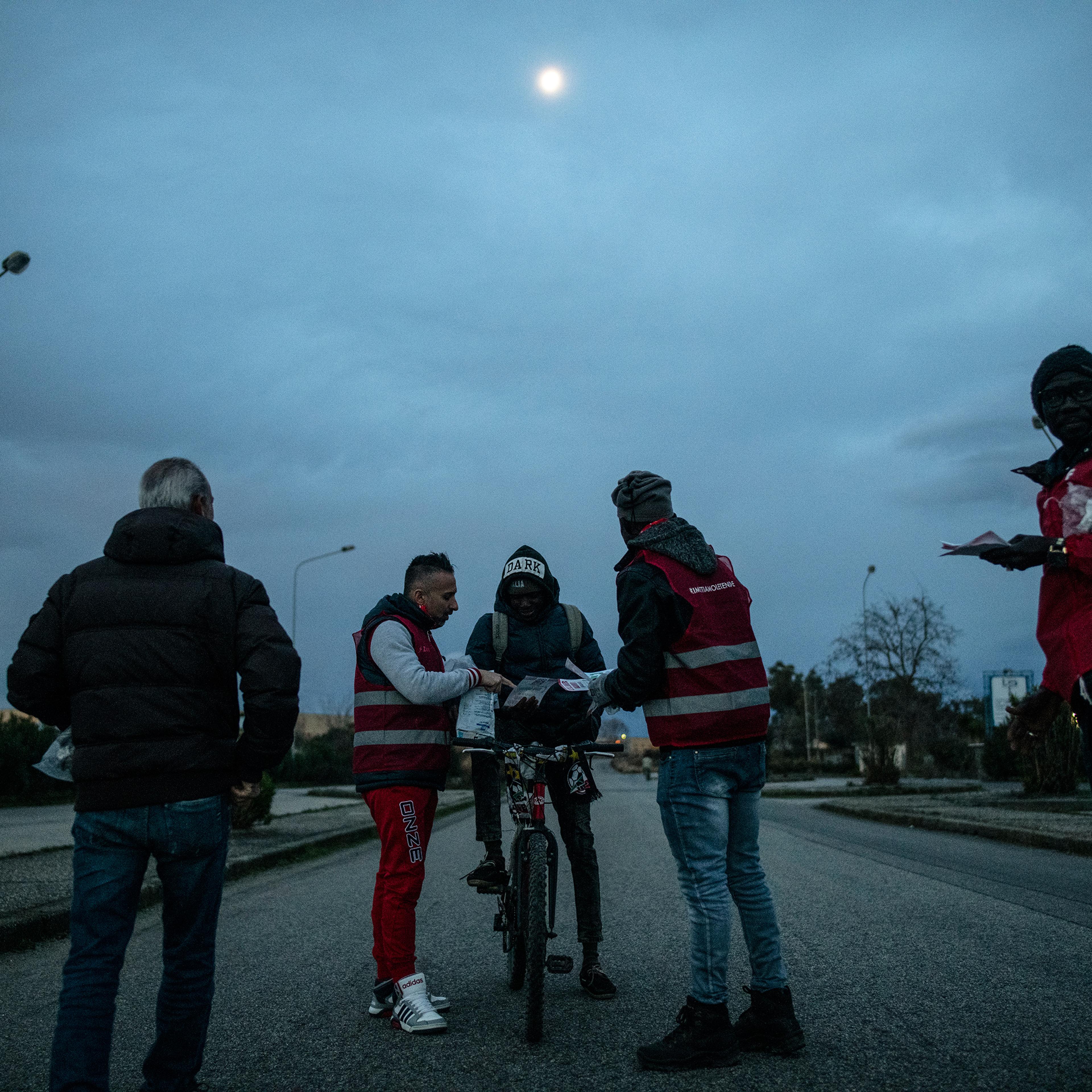 Migrant workers receive educational pamphlets about their rights in Italy, Jan. 24, 2019.