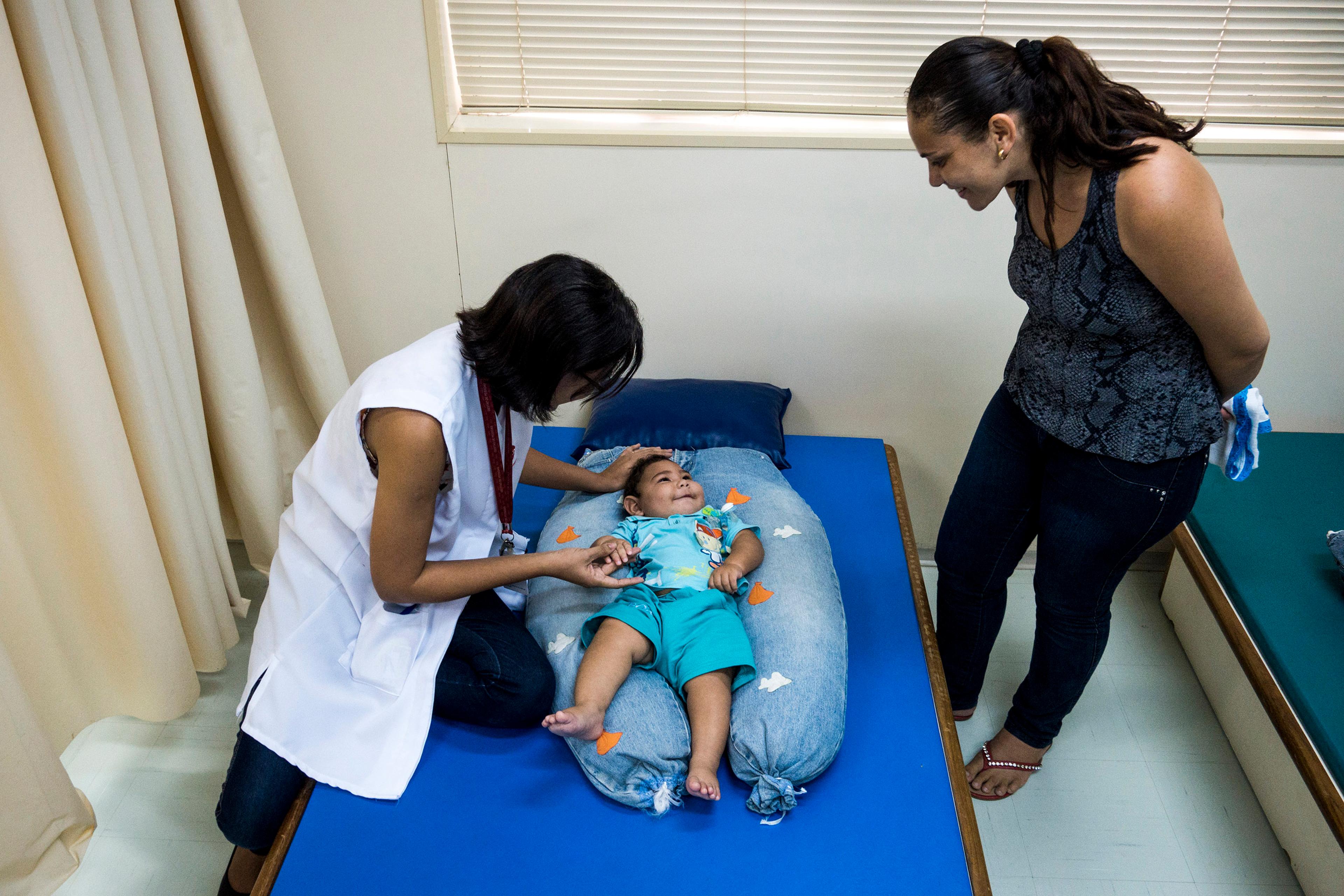 Dr. Cynthia de Melo Silva Ximenes, a physical therapist, works with Adriana Cordeiro da Silva, 29, and her 7-month-year-old son Jose Bernardo at the Associacao de Assistencia a Crianca Deficiente rehabilitation center in Recife, Brazil, Feb. 1, 2016. She