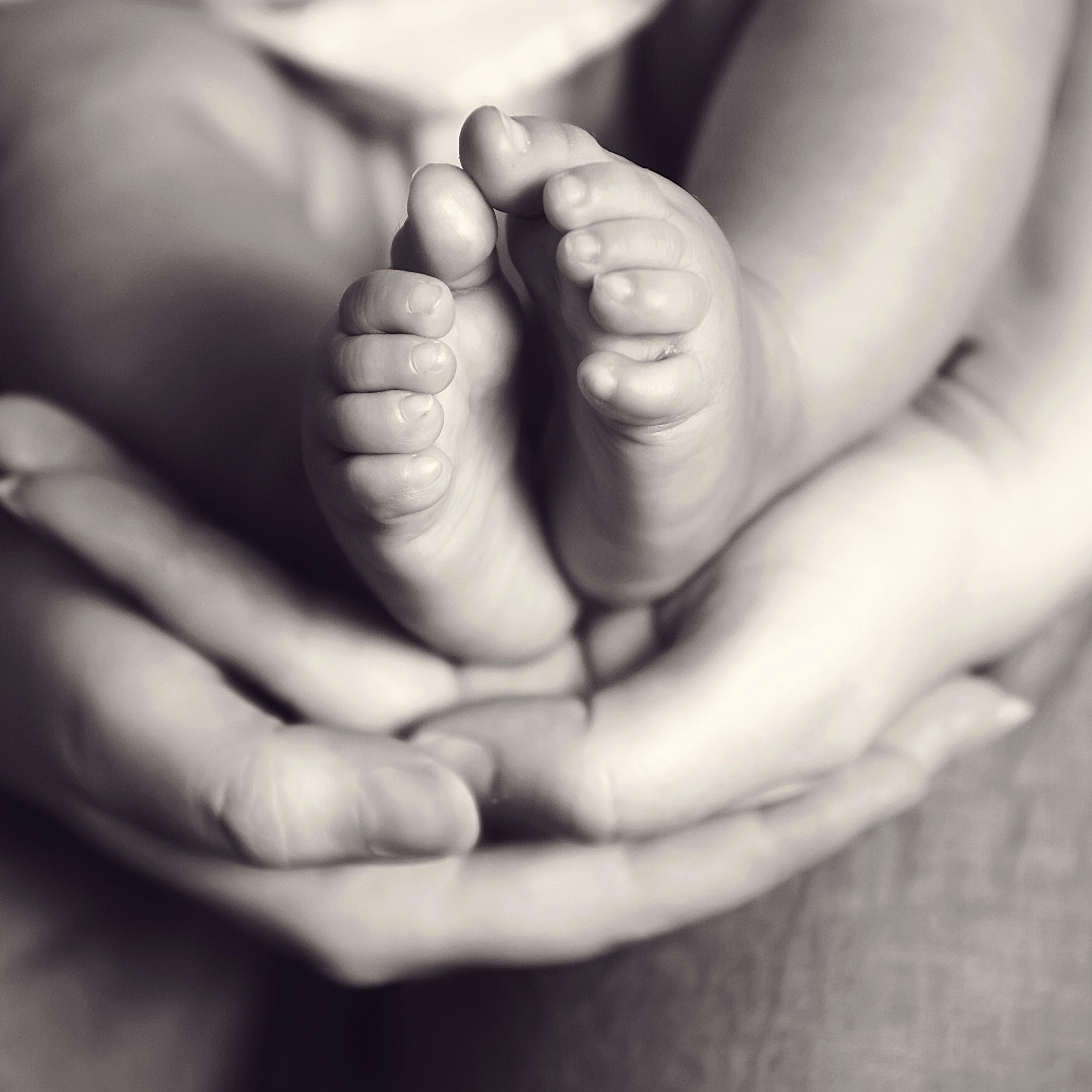 Infant feet and adult hands