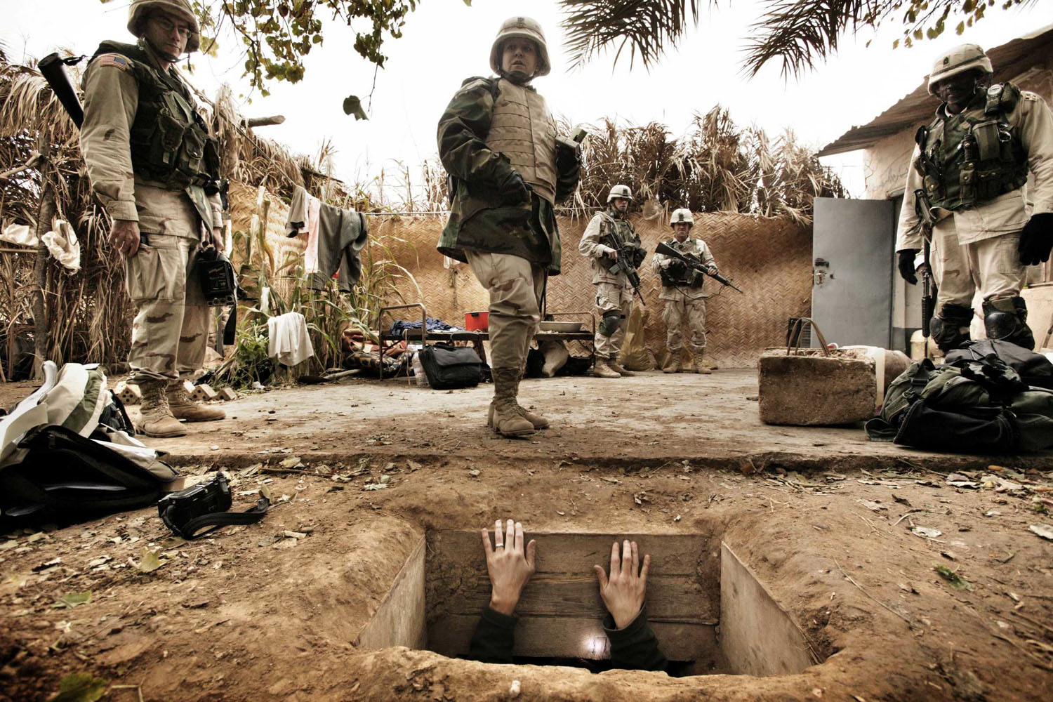 A journalist climbs out of the hole where toppled dictator Saddam Hussein was captured in Ad Dawr. Iraq’s defeated leader raised his arms out of his “rat hole” and said he was Saddam Hussein and that he wanted to negotiate. Iraq, December 15, 2003
