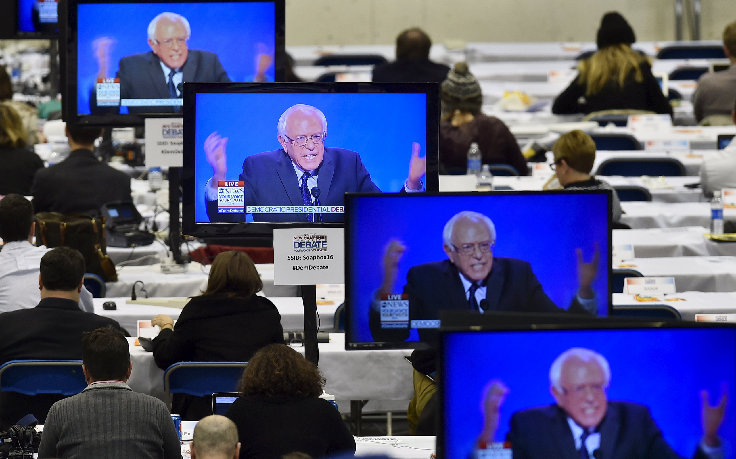 U.S. Democratic presidential candidate Bernie Sanders appears on television screens in the media work-room during the Democratic presidential candidates debate at Saint Anselm College in Manchester, New Hampshire December 19, 2015. REUTERS/Gretchen Ertl 