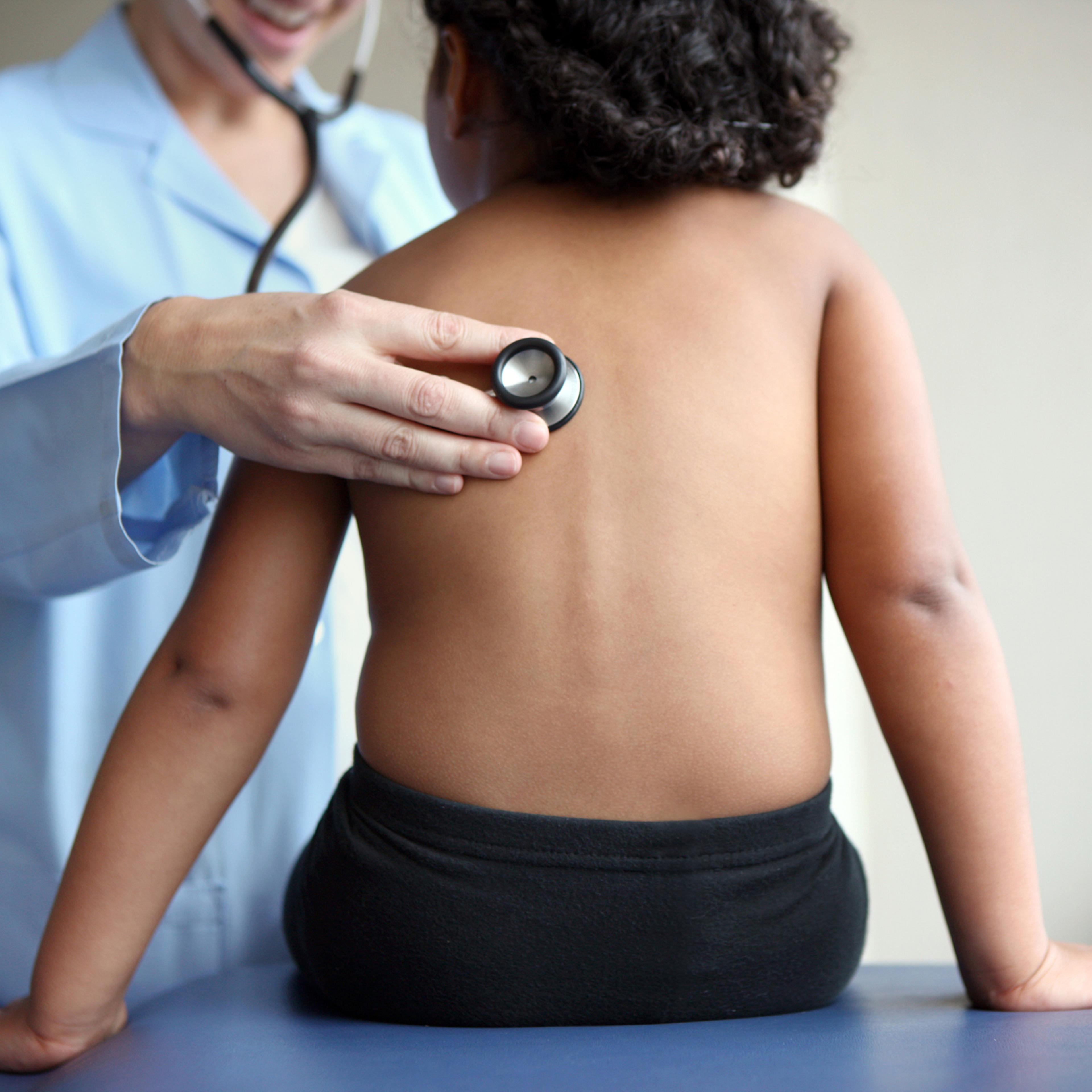 Doctor listens to girl's breathing.