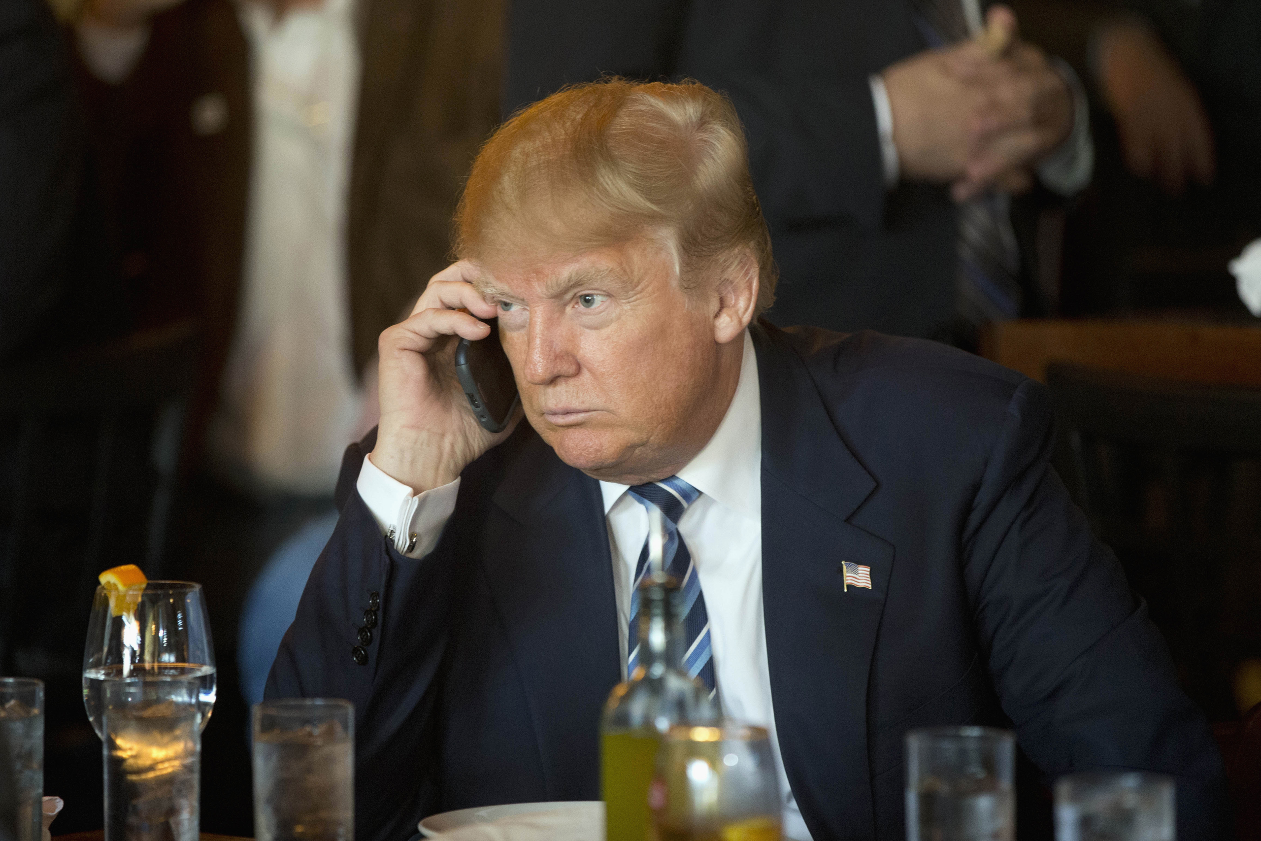 Republican presidential candidate Donald Trump listens to his mobile phone during a lunch stop in North Charleston, S.C. on Feb. 18, 2016.