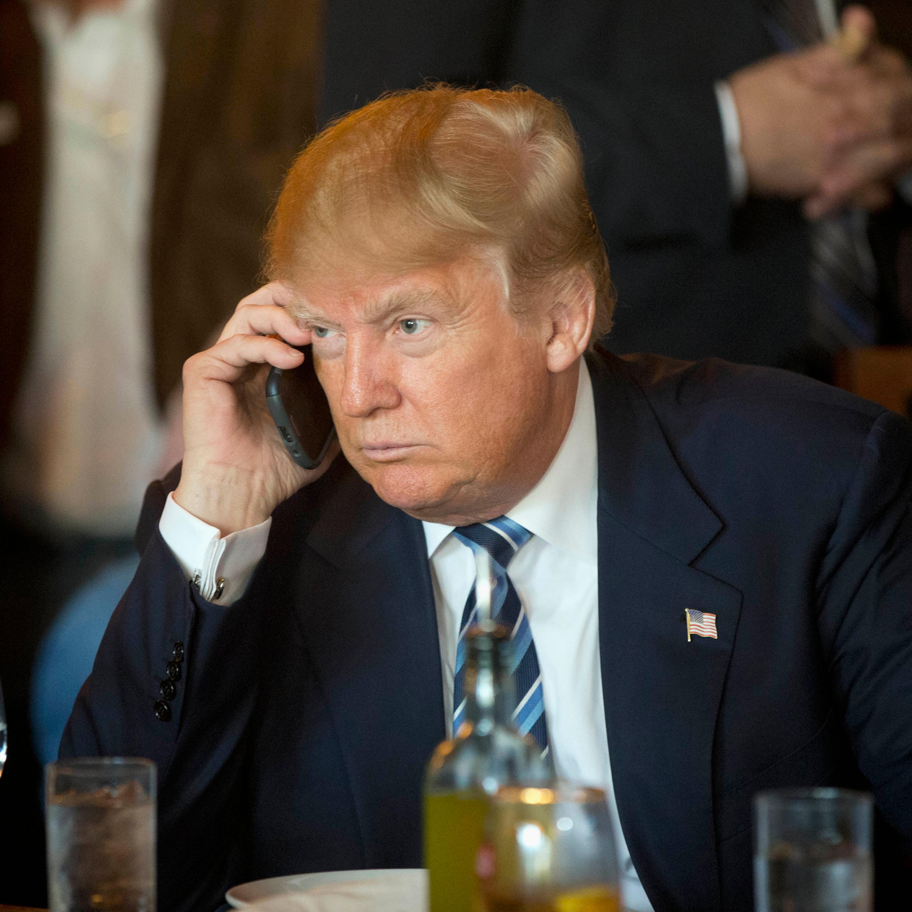 Republican presidential candidate Donald Trump listens to his mobile phone during a lunch stop in North Charleston, S.C. on Feb. 18, 2016.