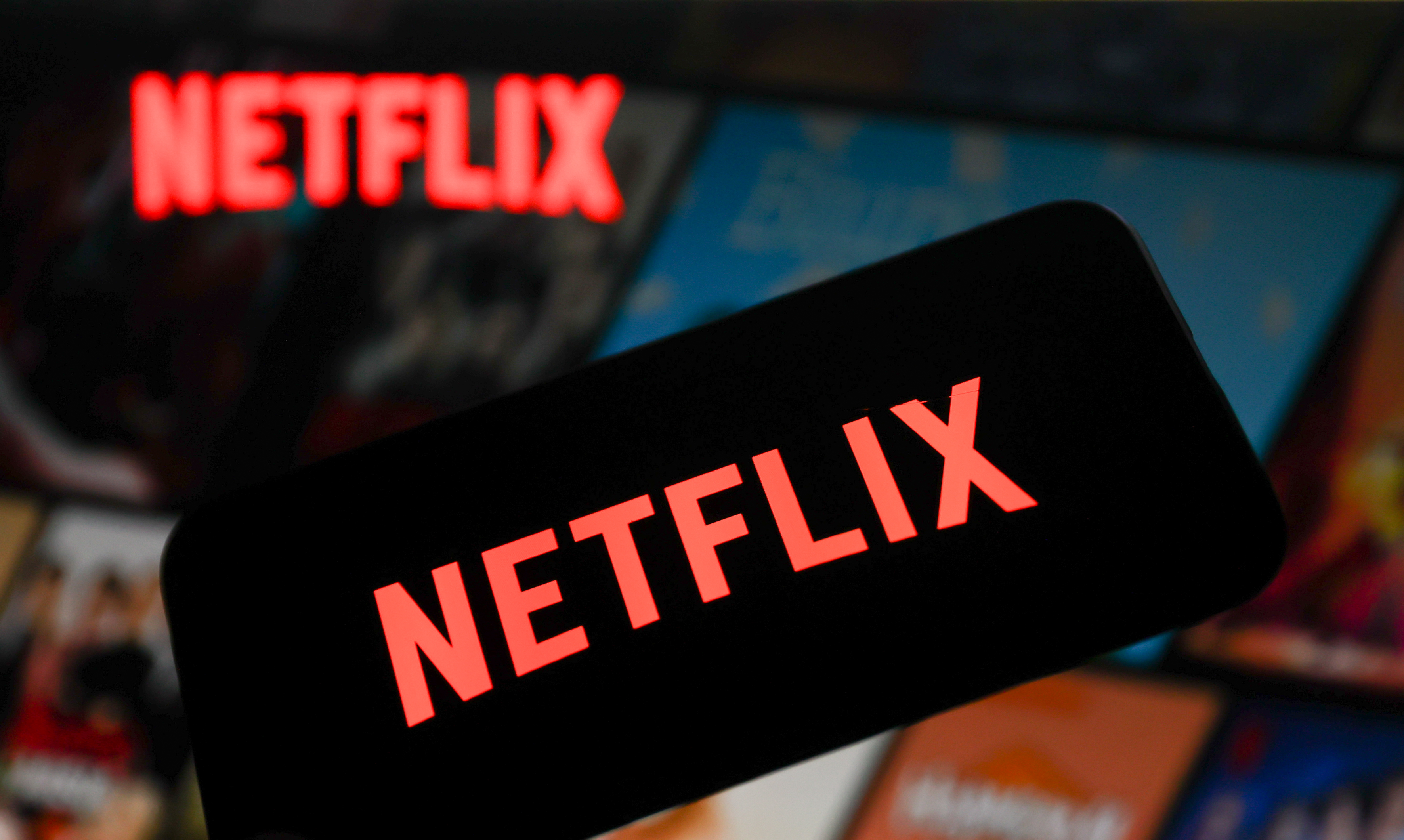 Netflix logo displayed on a phone screen and Netflix website displayed on a laptop screen are seen in this photo illustration.