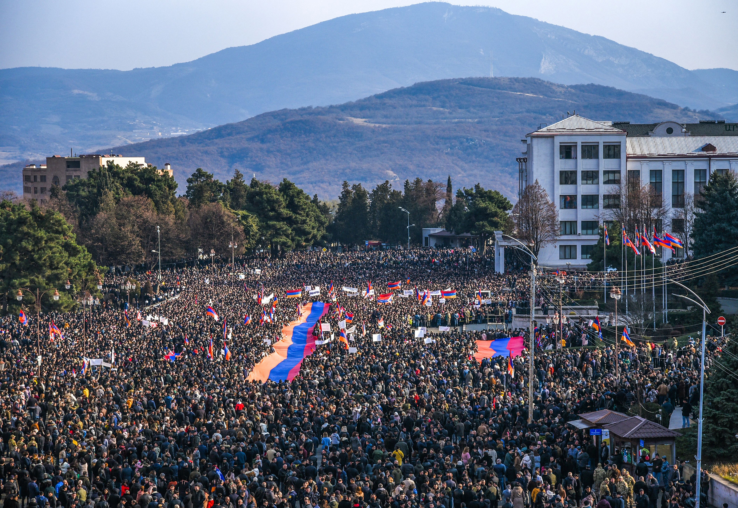 Protesters hold a giant Armenian flag as they attend a rally in Stepanakert, in Nagorno-Karabakh, on Dec. 25, 2022. Thousands rallied to protest Azerbaijan's blockade of the only land link to Armenia. 