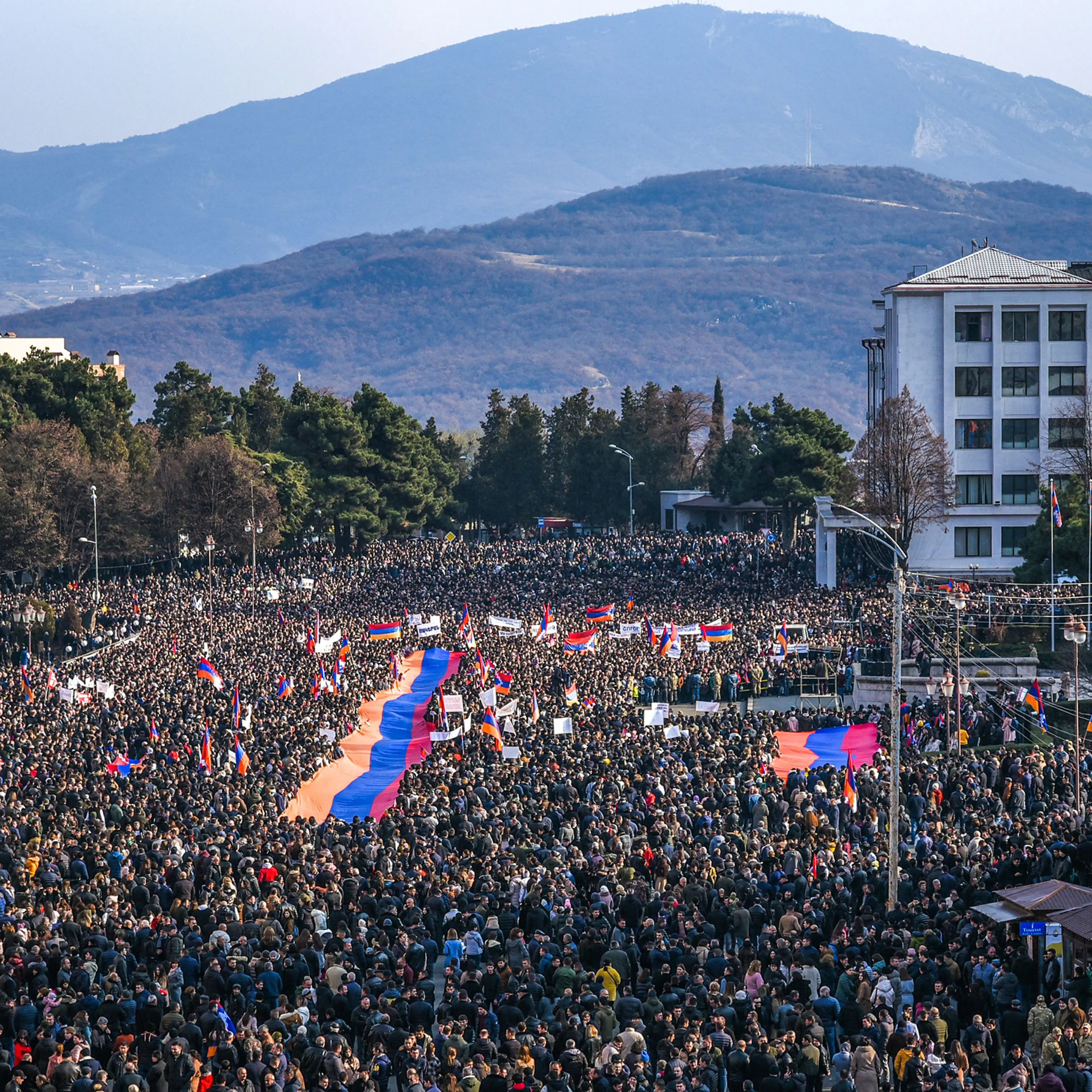 Protesters hold a giant Armenian flag as they attend a rally in Stepanakert, in Nagorno-Karabakh, on Dec. 25, 2022. Thousands rallied to protest Azerbaijan's blockade of the only land link to Armenia.