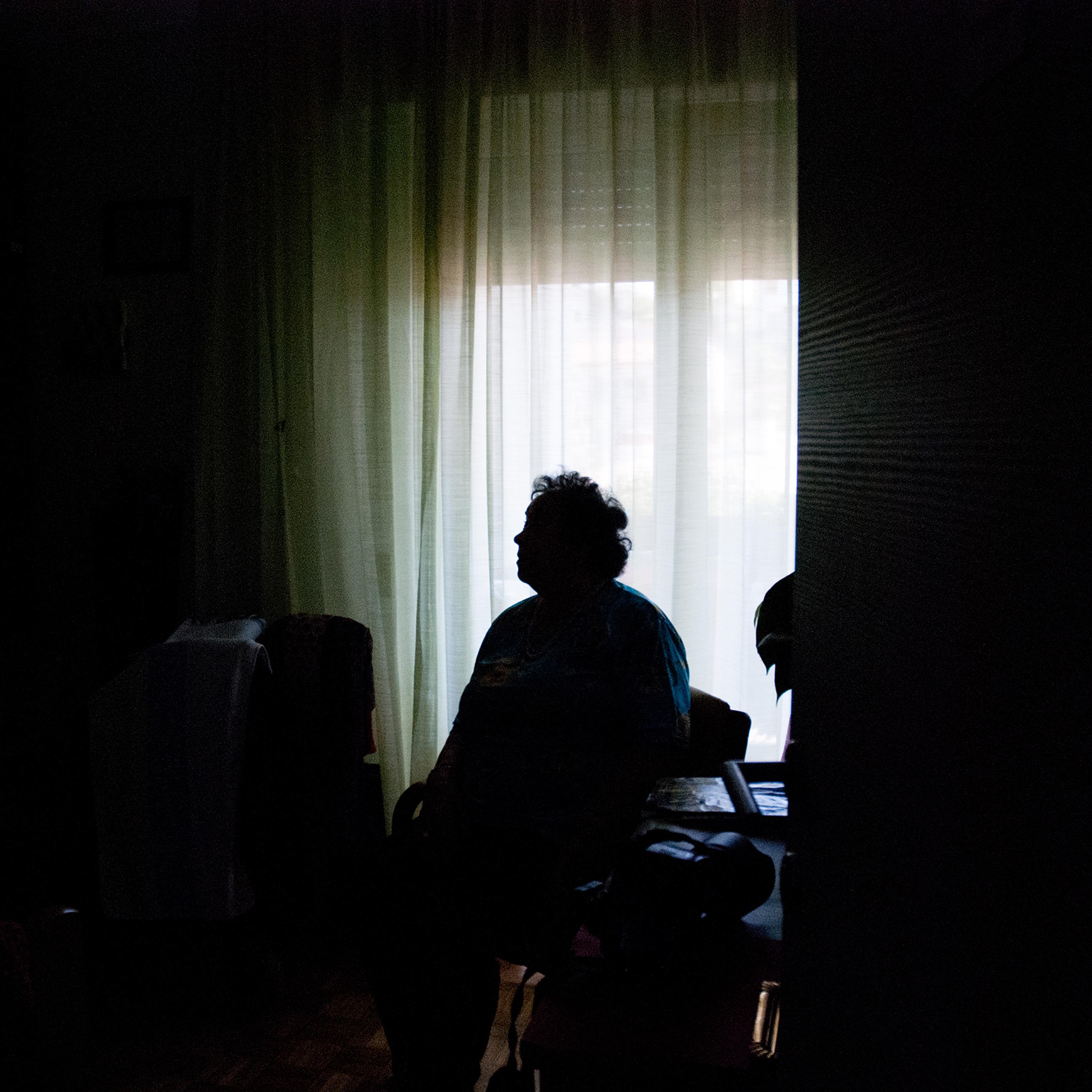 Senior Woman Alone in Dark Room