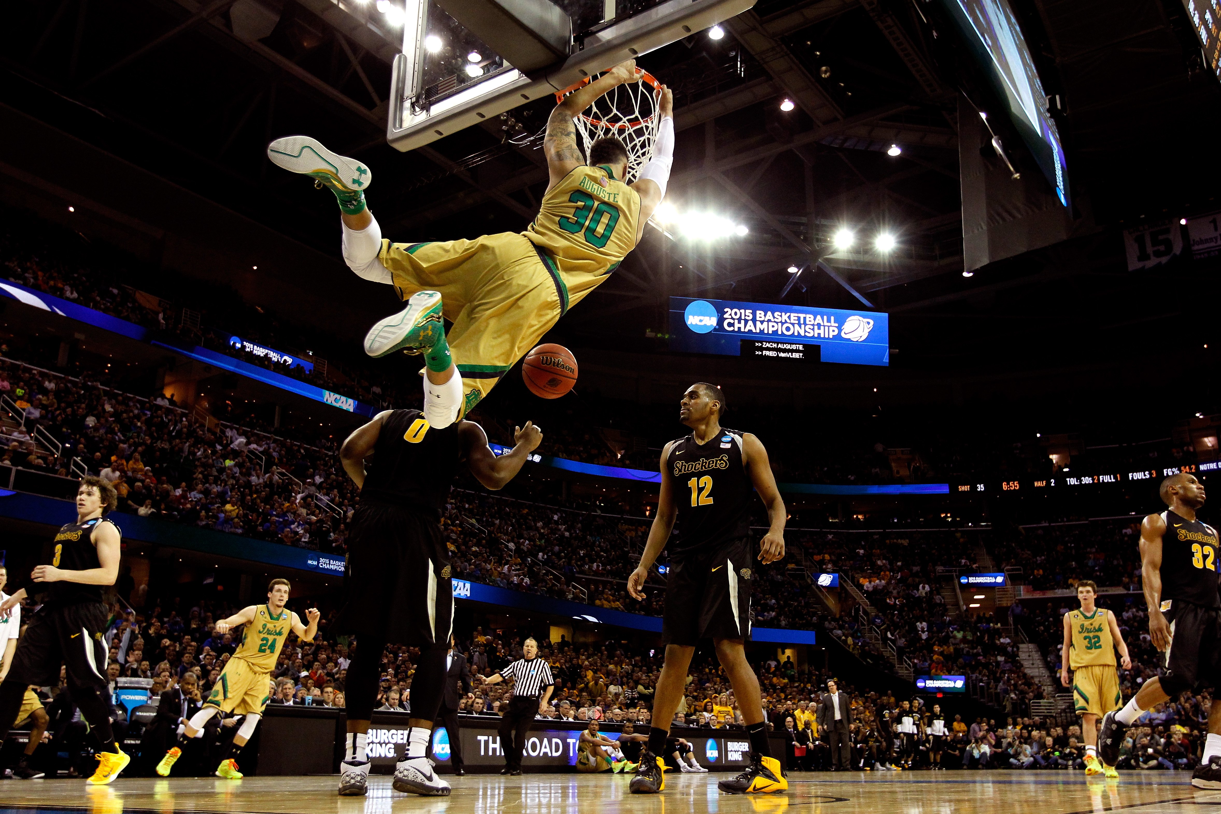 Zach Auguste #30 of the Notre Dame Fighting Irish dunks in the second half against Rashard Kelly #0 and Darius Carter #12 of the Wichita State Shockers during the Midwest Regional semifinal of the 2015 NCAA Men's Basketball Tournament at Quicken Loans Ar