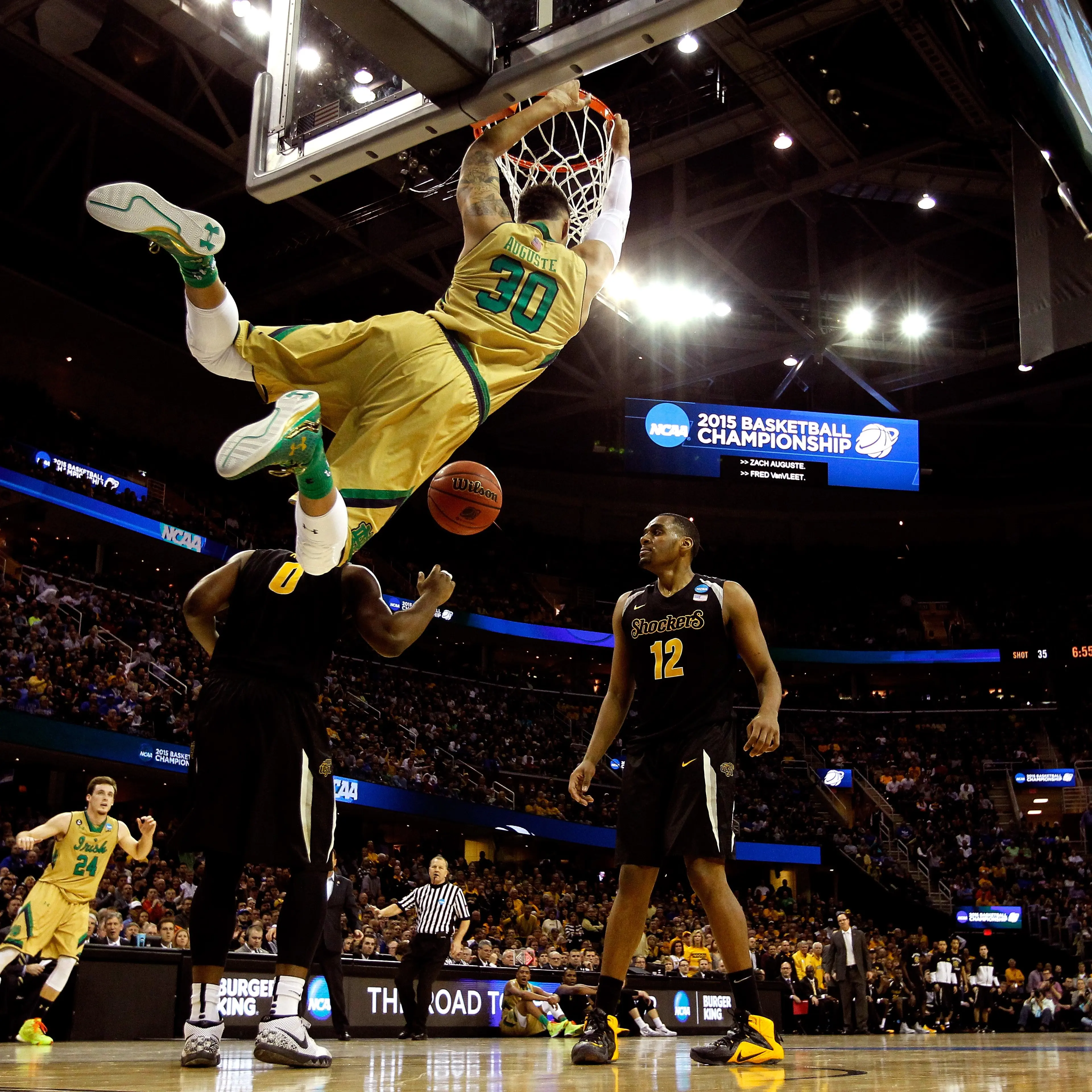 Zach Auguste #30 of the Notre Dame Fighting Irish dunks in the second half against Rashard Kelly #0 and Darius Carter #12 of the Wichita State Shockers during the Midwest Regional semifinal of the 2015 NCAA Men's Basketball Tournament at Quicken Loans Ar