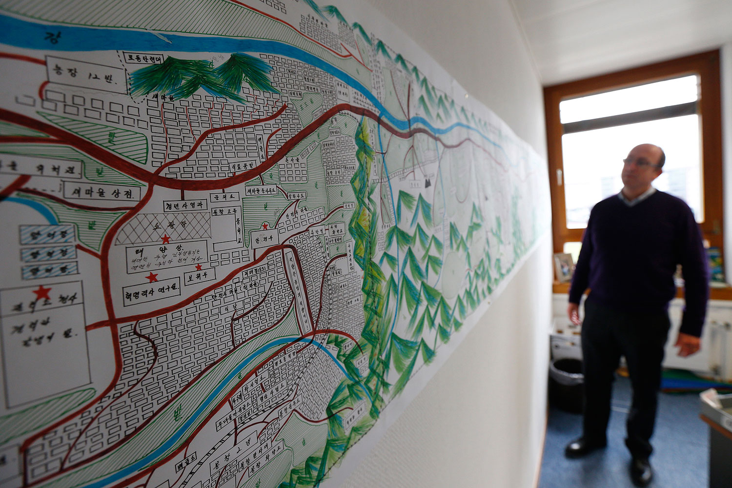 A United Nations Human Rights staff stands in front of a drawing illustrating North Korean labour camp no 18 in Geneva Feb. 17, 2014