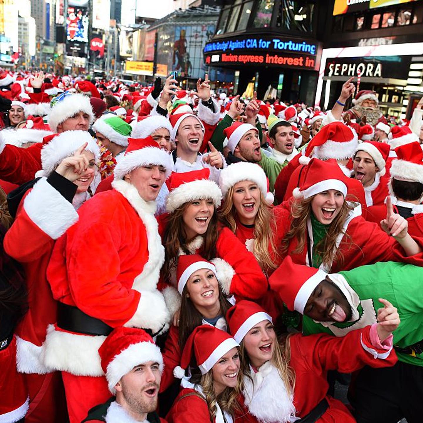 People dressed as Santa Claus and Mrs. Claus pose in Times Square as they gather for the annual Santacon festivities on Dec. 13, 2014 in New York City.