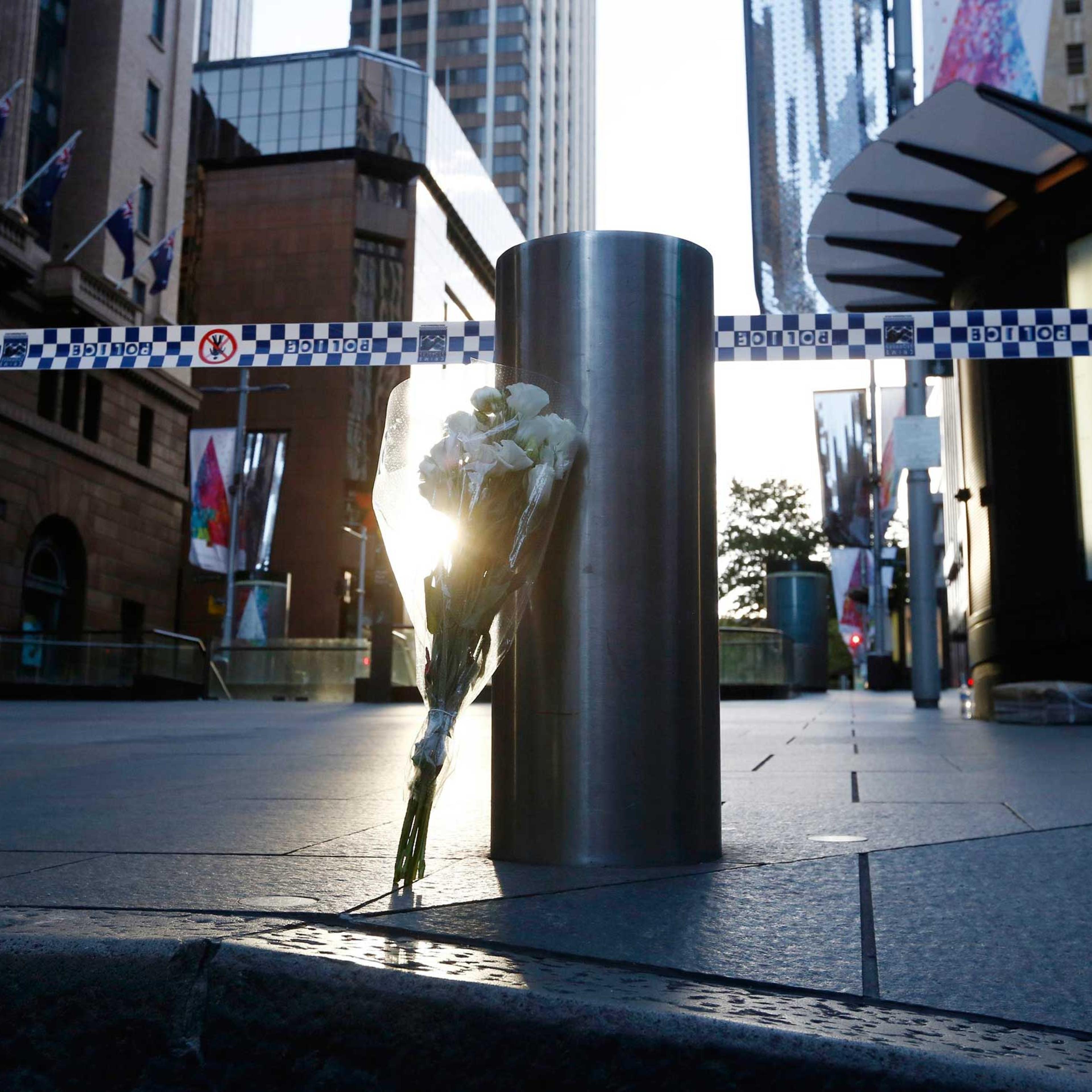 A bouquet is pictured under police tape near the cordoned-off scene of a hostage taking at Martin Place after it ended, early on Dec. 16, 2014.