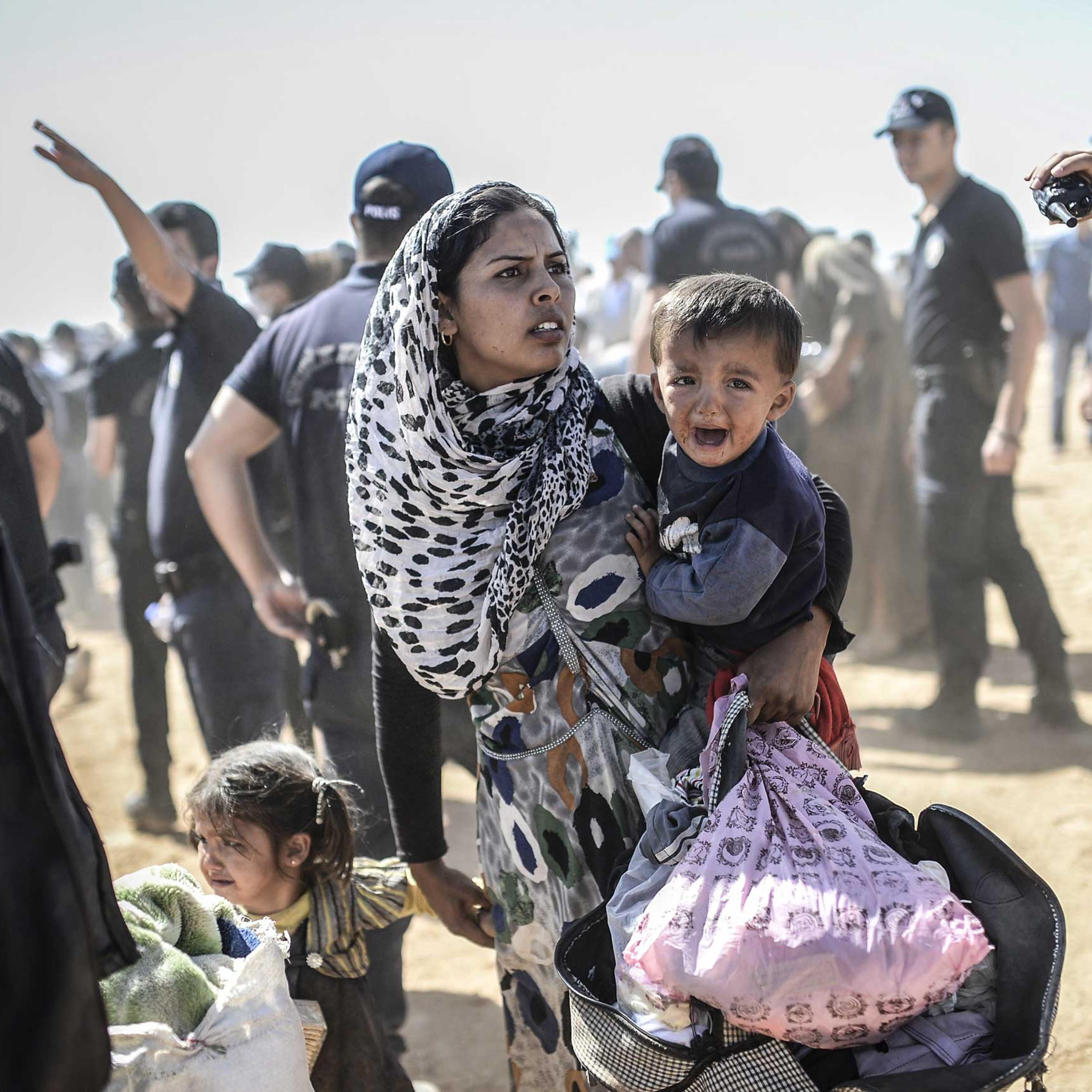 A Syrian Kurdish woman crosses the border between Syria and Turkey at the southeastern town of Suruc in Sanliurfa province on Sept. 23, 2014.