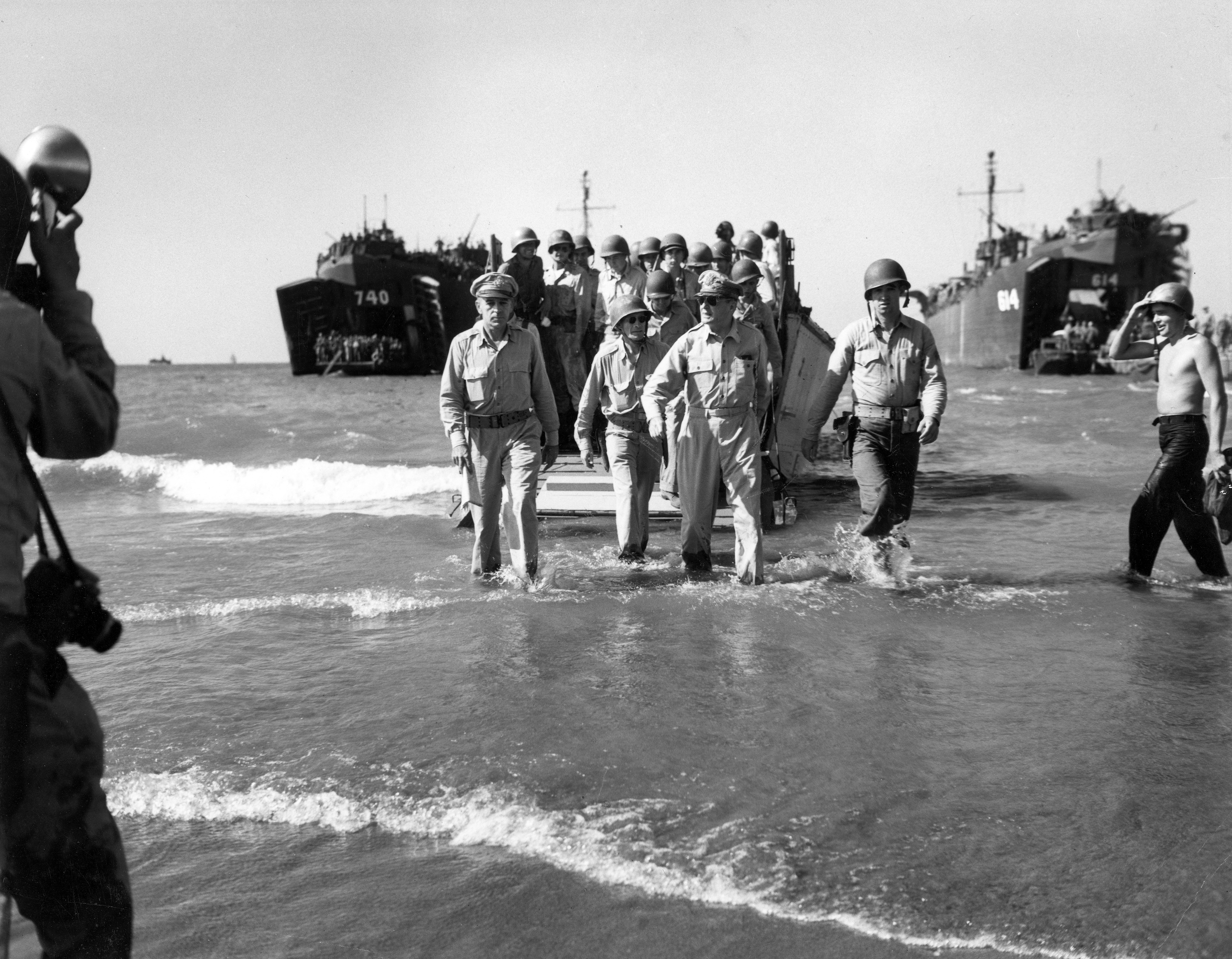 Gen. Douglas MacArthur with Gen. Richard Sutherland (left) and Col. Lloyd Lehrbas (second from left) walks through the surf to the beach at Lingayen, Luzon, the Philippines, Jan. 9, 1945.
