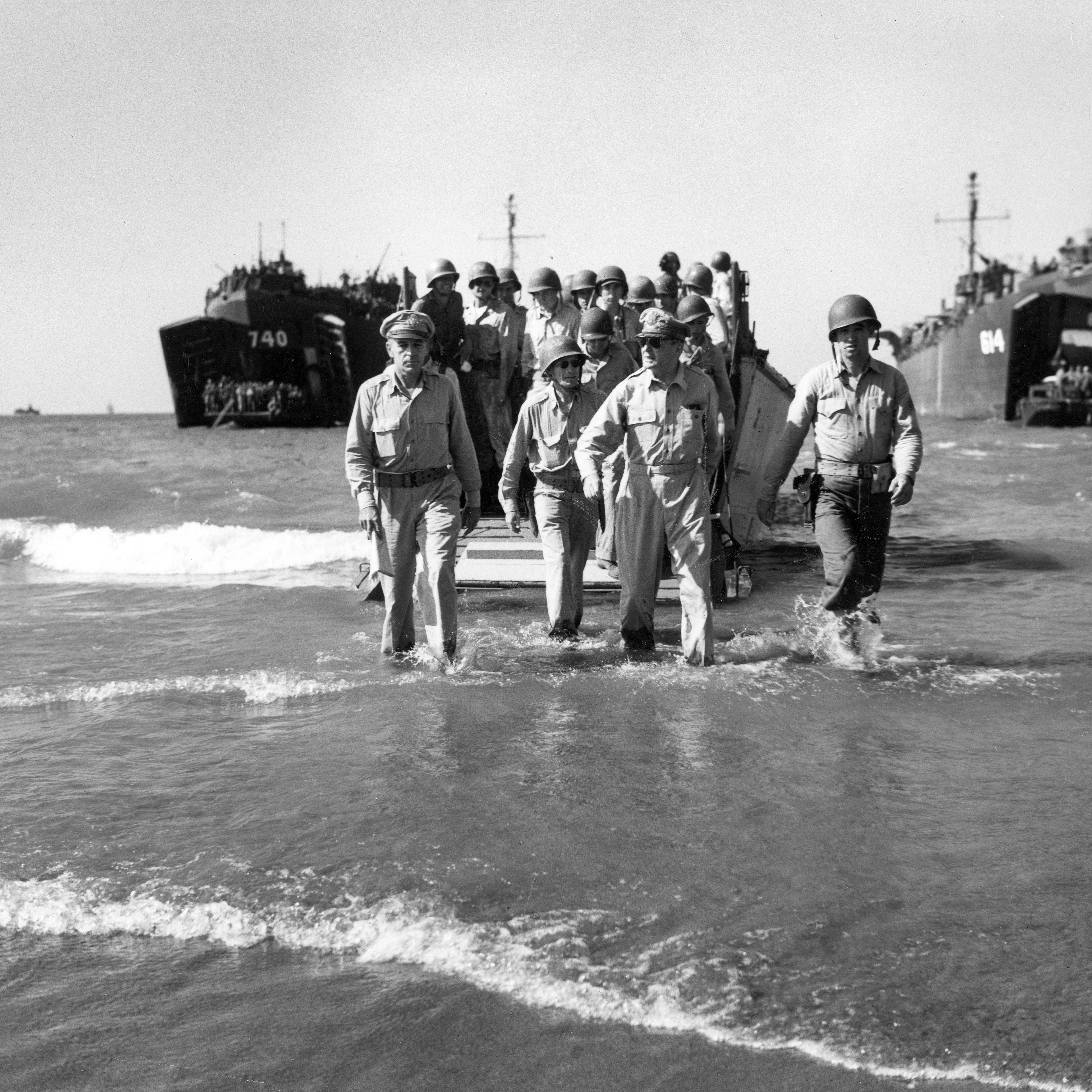 Gen. Douglas MacArthur with Gen. Richard Sutherland (left) and Col. Lloyd Lehrbas (second from left) walks through the surf to the beach at Lingayen, Luzon, the Philippines, Jan. 9, 1945.