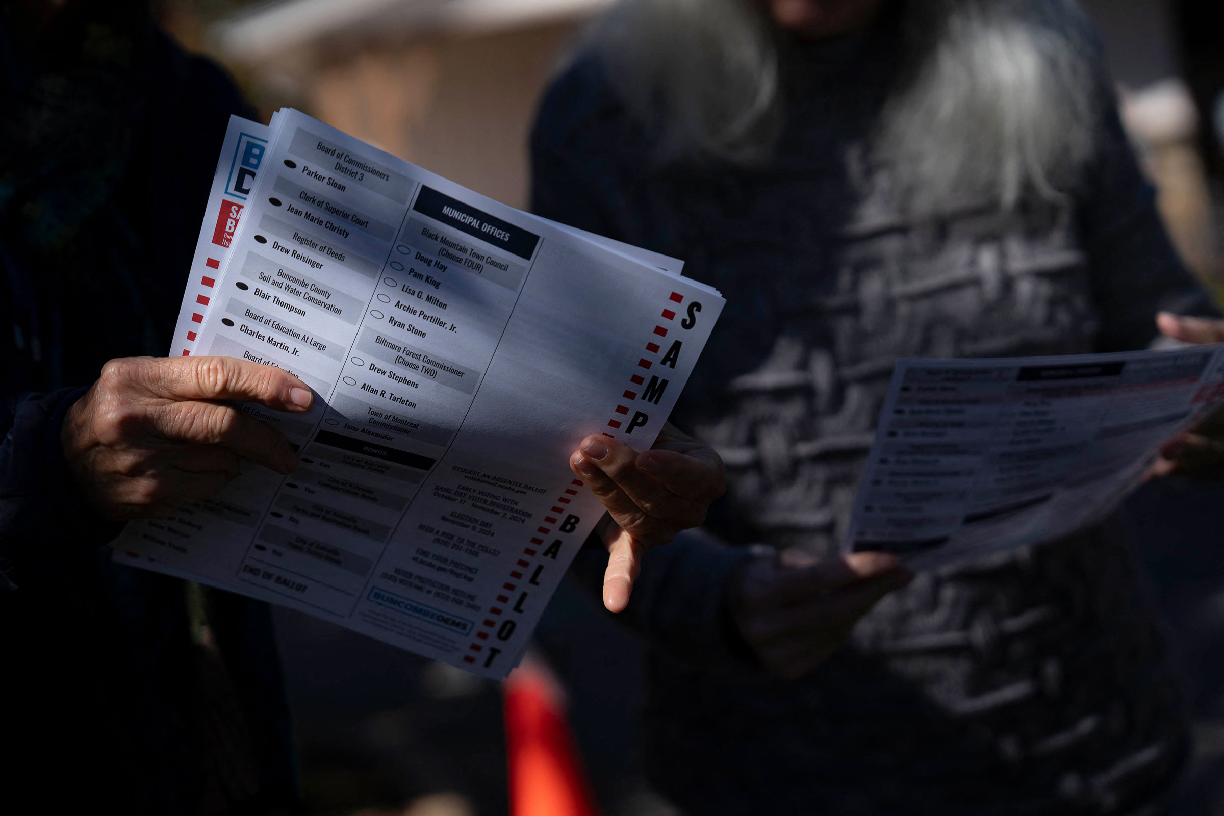 A woman holds a sample ballot on Oct. 18, the second day of early voting in North Carolina