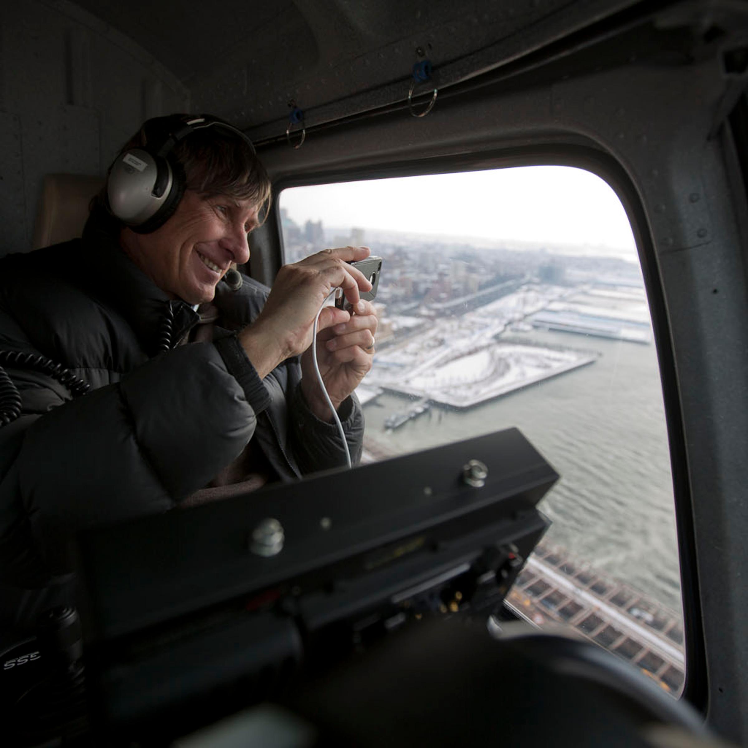 Aerial cinematographer Doug Holgate snaps a photo with his iPHone while flying over the Brooklyn Bridge