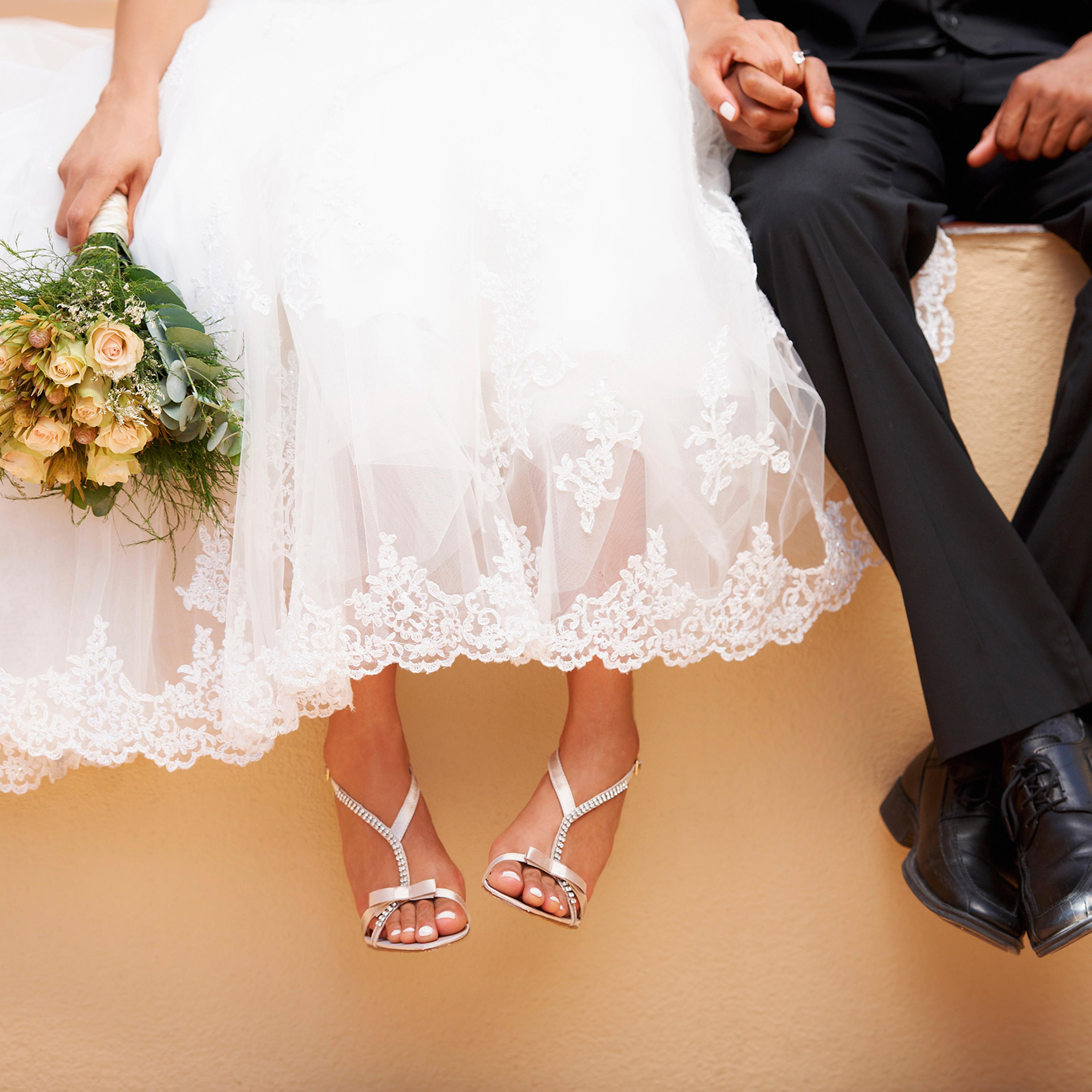 South Africa, Cape Town, Bride and groom sitting on wall