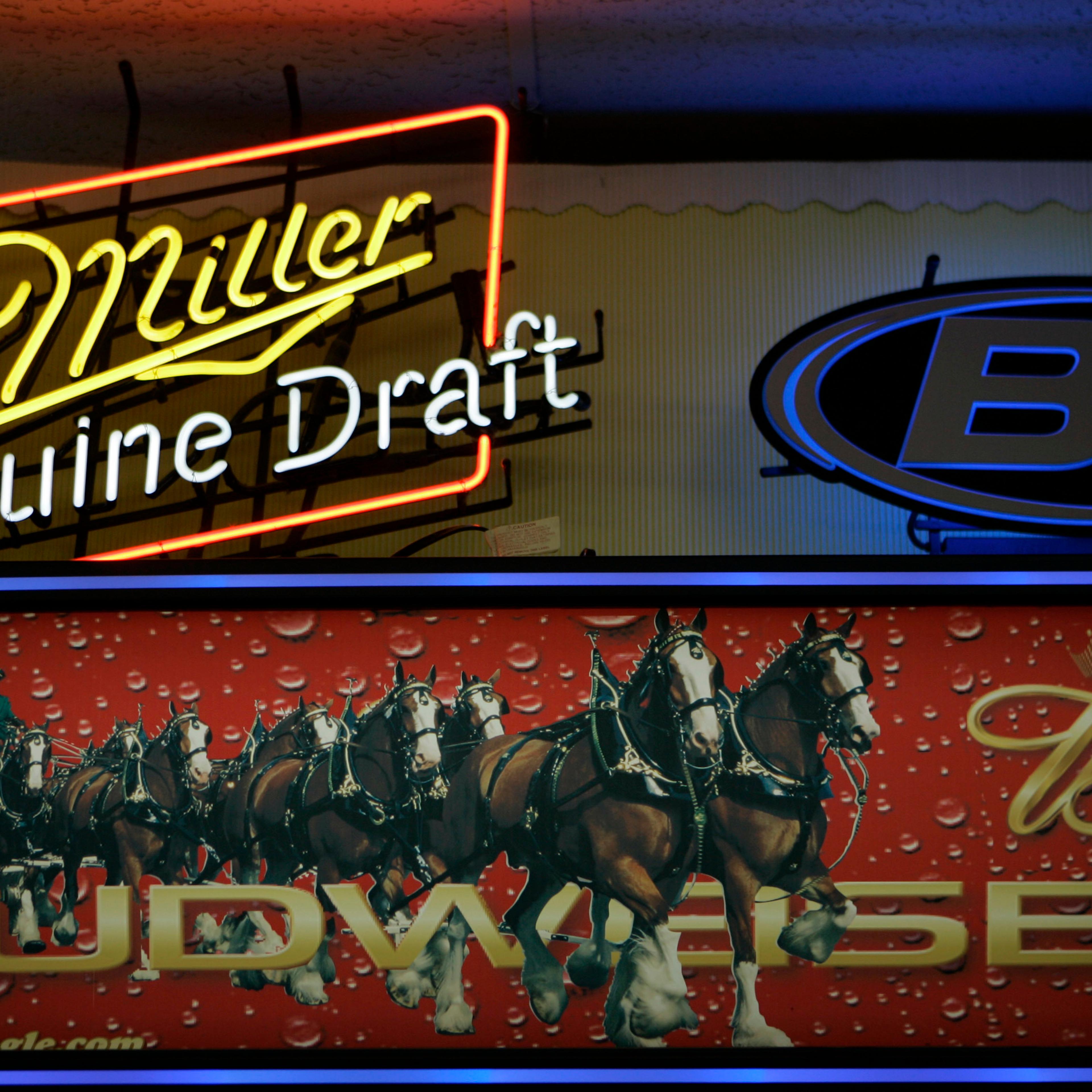 Signs for Miller and Anheuser-Busch products above a liquor store cooler in St. Louis, Oct. 23, 2007. Anheuser-Busch InBev, the world's largest beer maker, announced July 20, 2016, that it has reached an agreement with the Justice Department clearing the