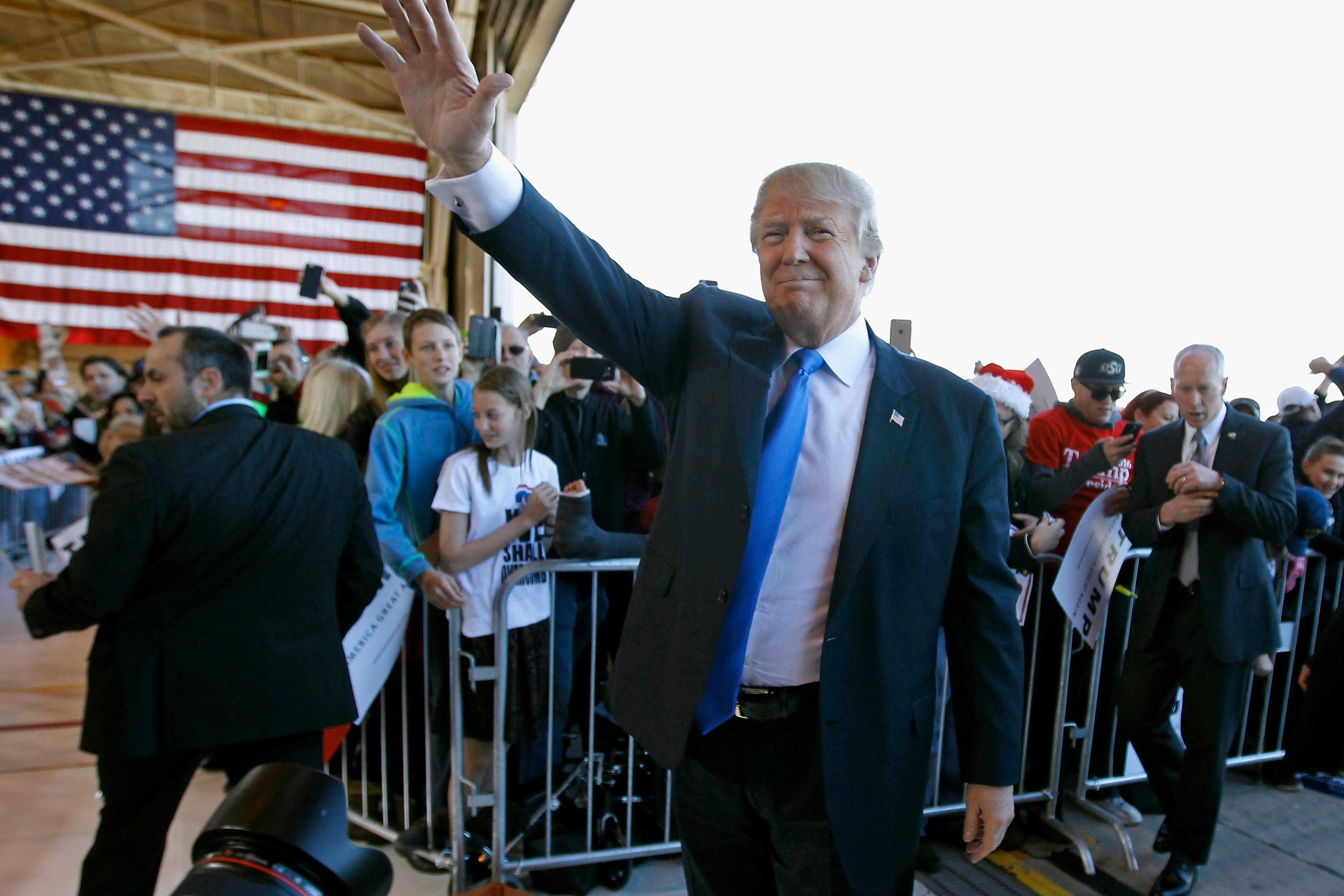 Donald Trump waves to the crowd as he arrives at a campaign event at the International Air Response facility on Dec. 16 in Mesa, Arizona.