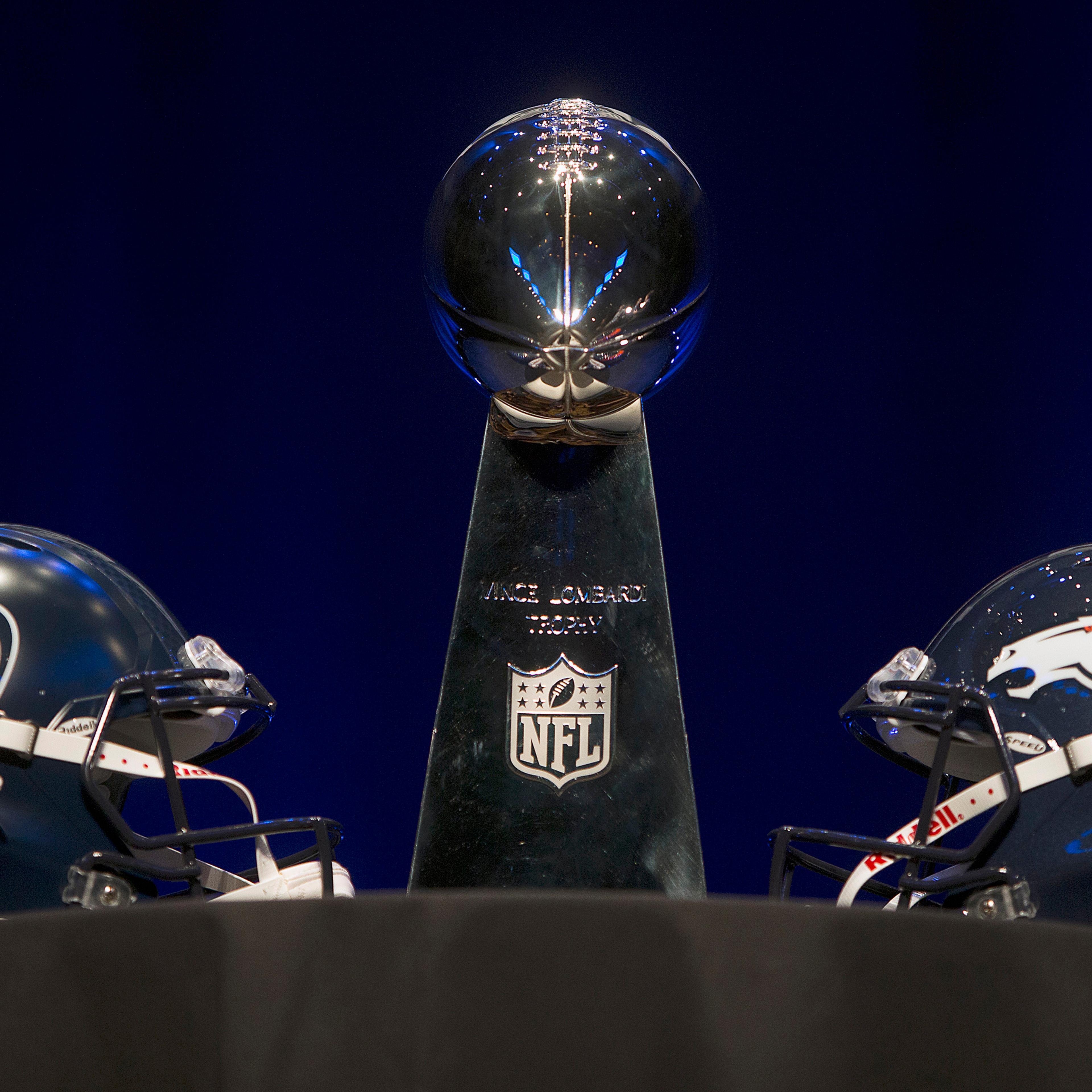 The Vince Lombardi trophy and Seattle Seahawks and Denver Broncos helmets at a press conference in advance of the Super Bowl in New York City, Jan. 31, 2014.