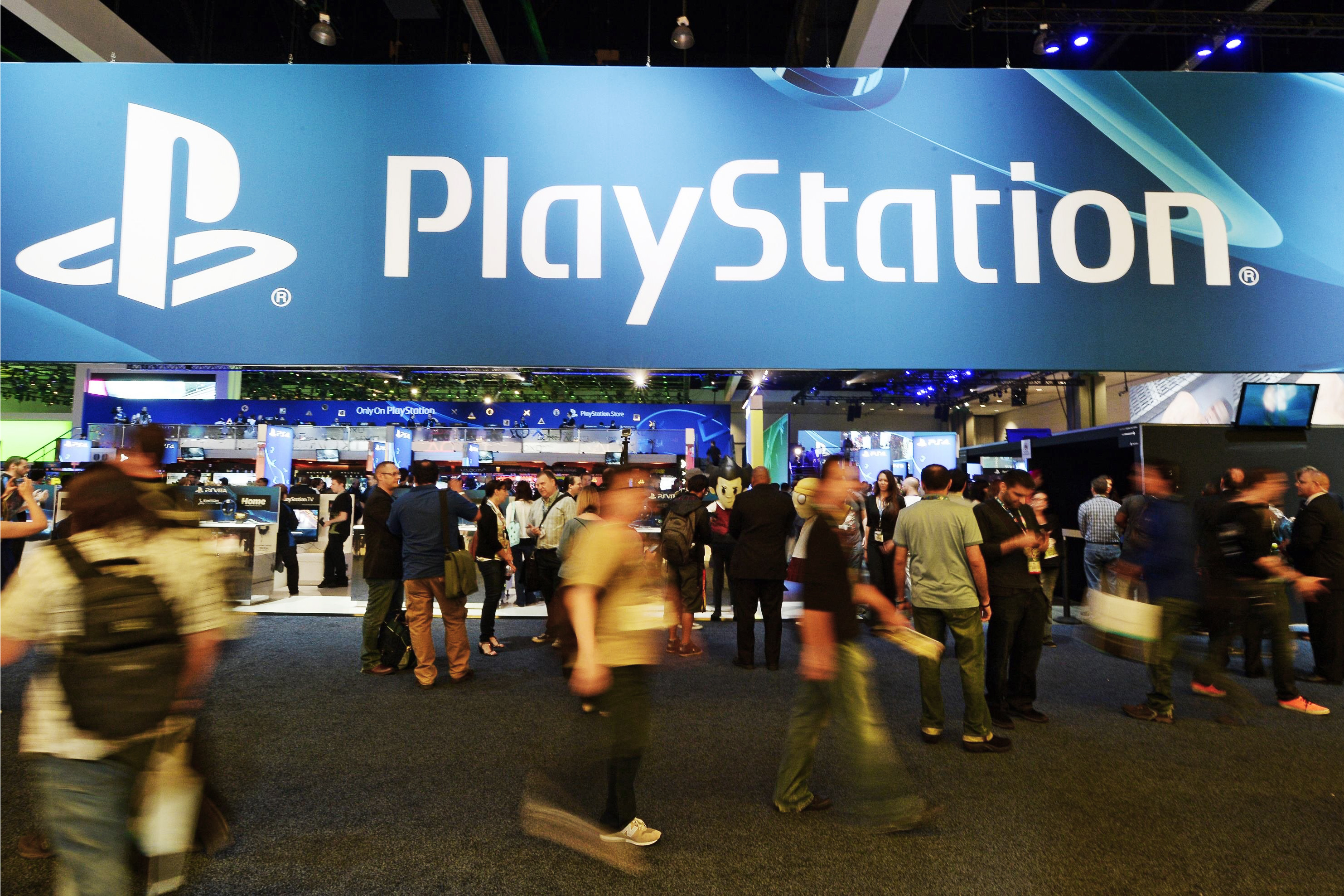 Attendees walk past the Sony Playstation booth at the 2014 Electronic Entertainment Expo, known as E3, in Los Angeles on June 11, 2014.