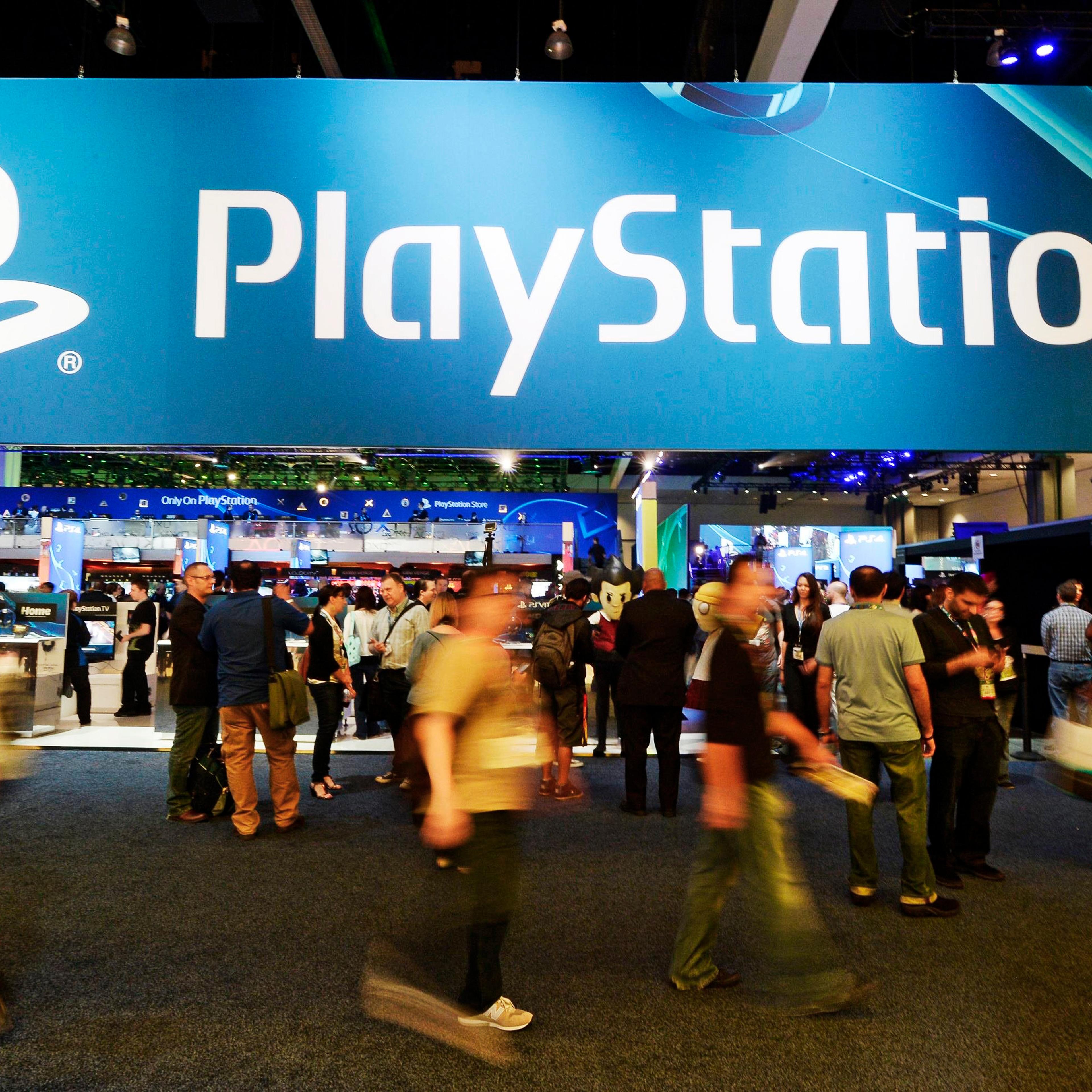 Attendees walk past the Sony Playstation booth at the 2014 Electronic Entertainment Expo, known as E3, in Los Angeles on June 11, 2014.