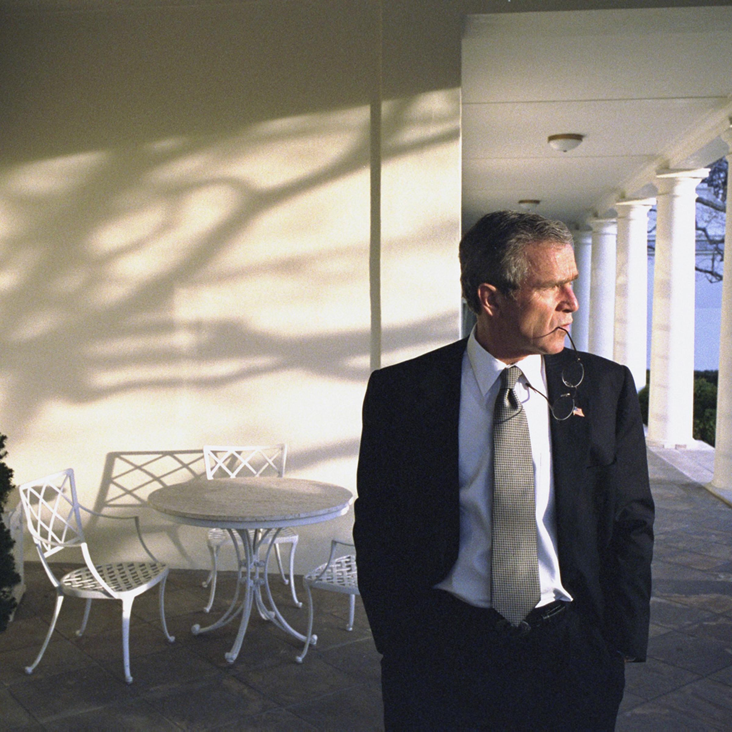Feb. 15, 2002. President Bush walks across the Colonnade to the Oval Office while taking a break between phone calls to world leaders.<br><br>“It’s ironic that this photo is on the cover of the book. I didn’t remember shooting it until a year later, when my photo editor Mike Davis brought it to me. I said who took that, it’s pretty good. He said, you did.”