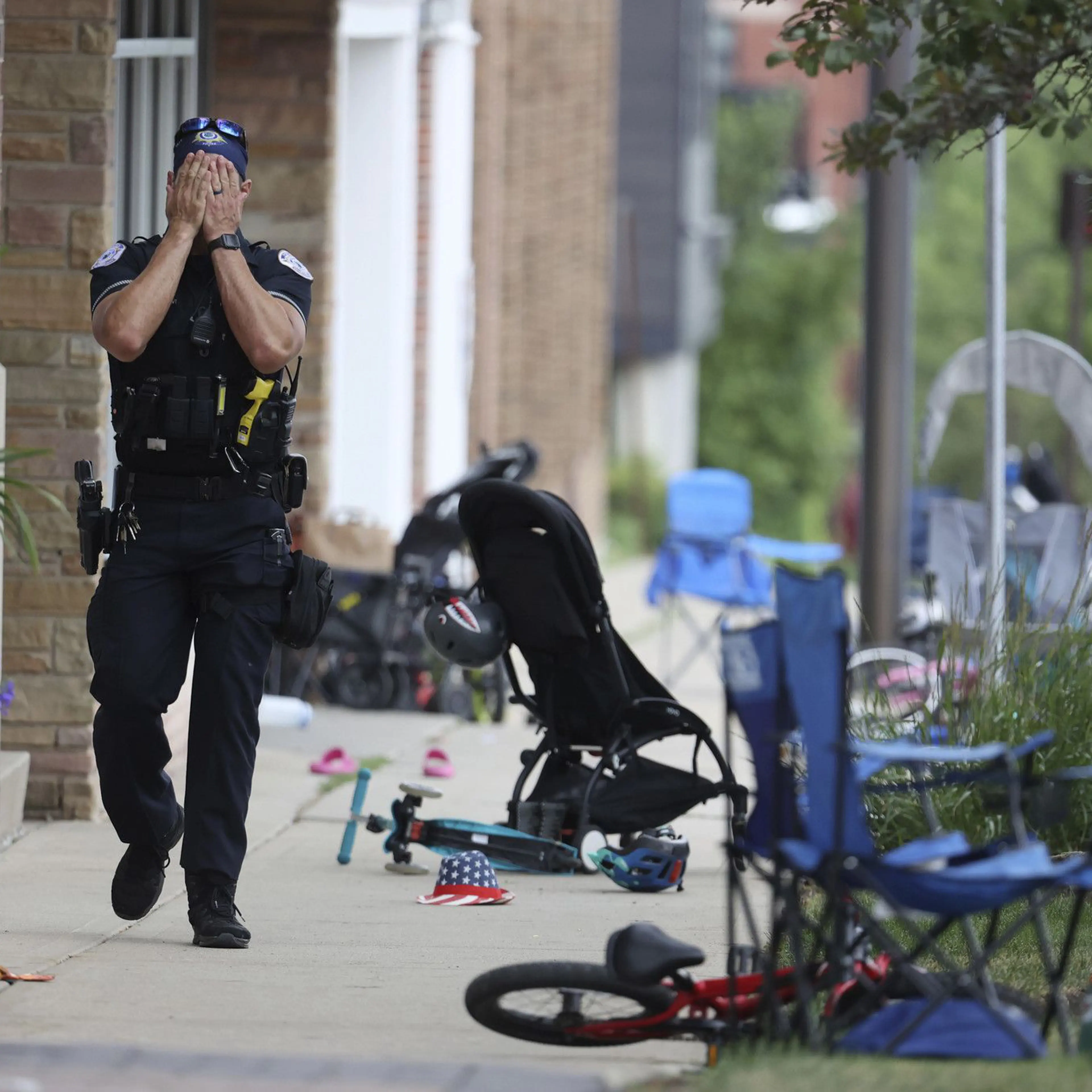 A Lake County, Illinois, police officer walks down Central Avenue in Highland Park on July 4, 2022, after a shooter fired on the northern suburb's Fourth of July parade. At least six people were killed and at least two dozen injured.