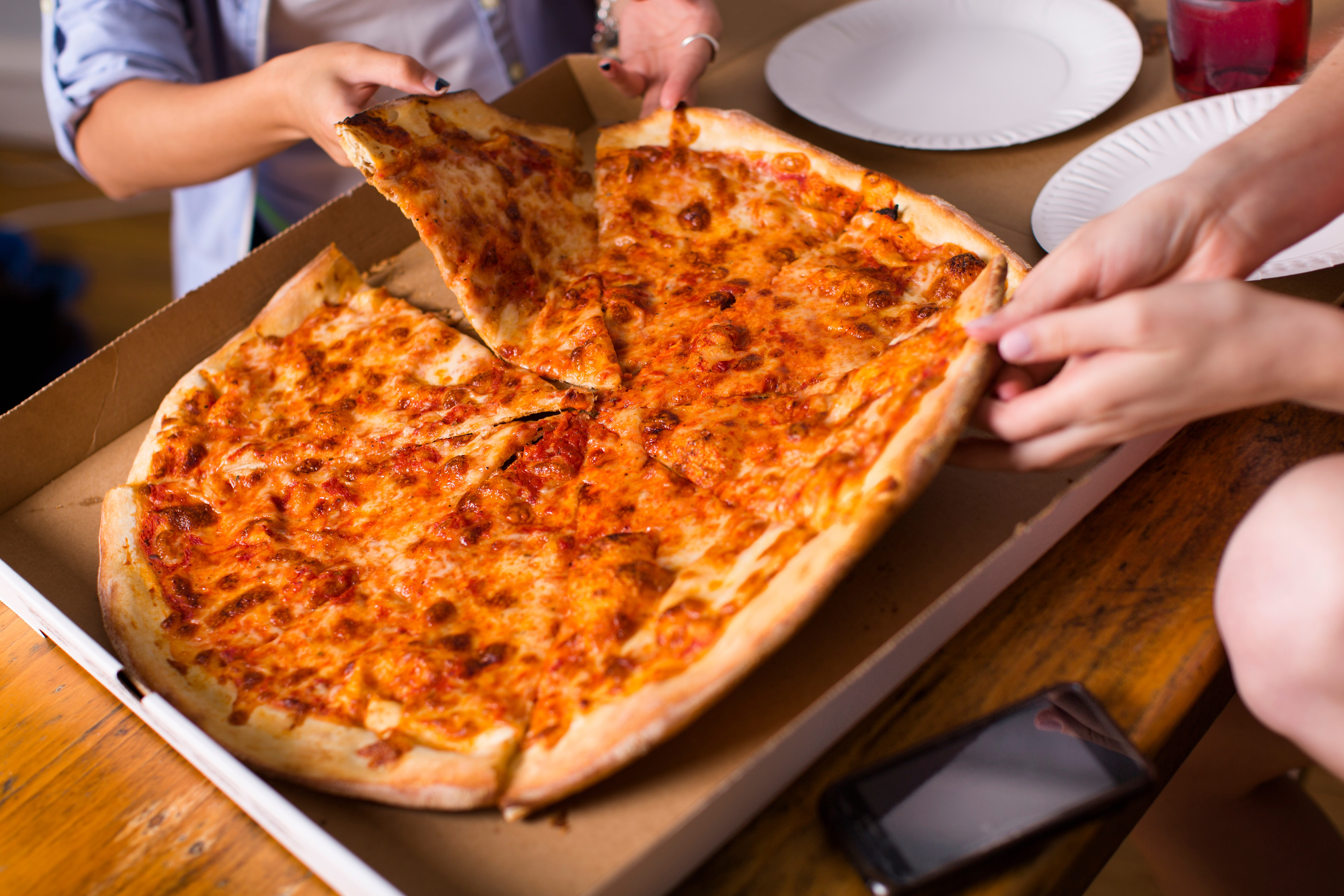 People sharing takeaway pizza