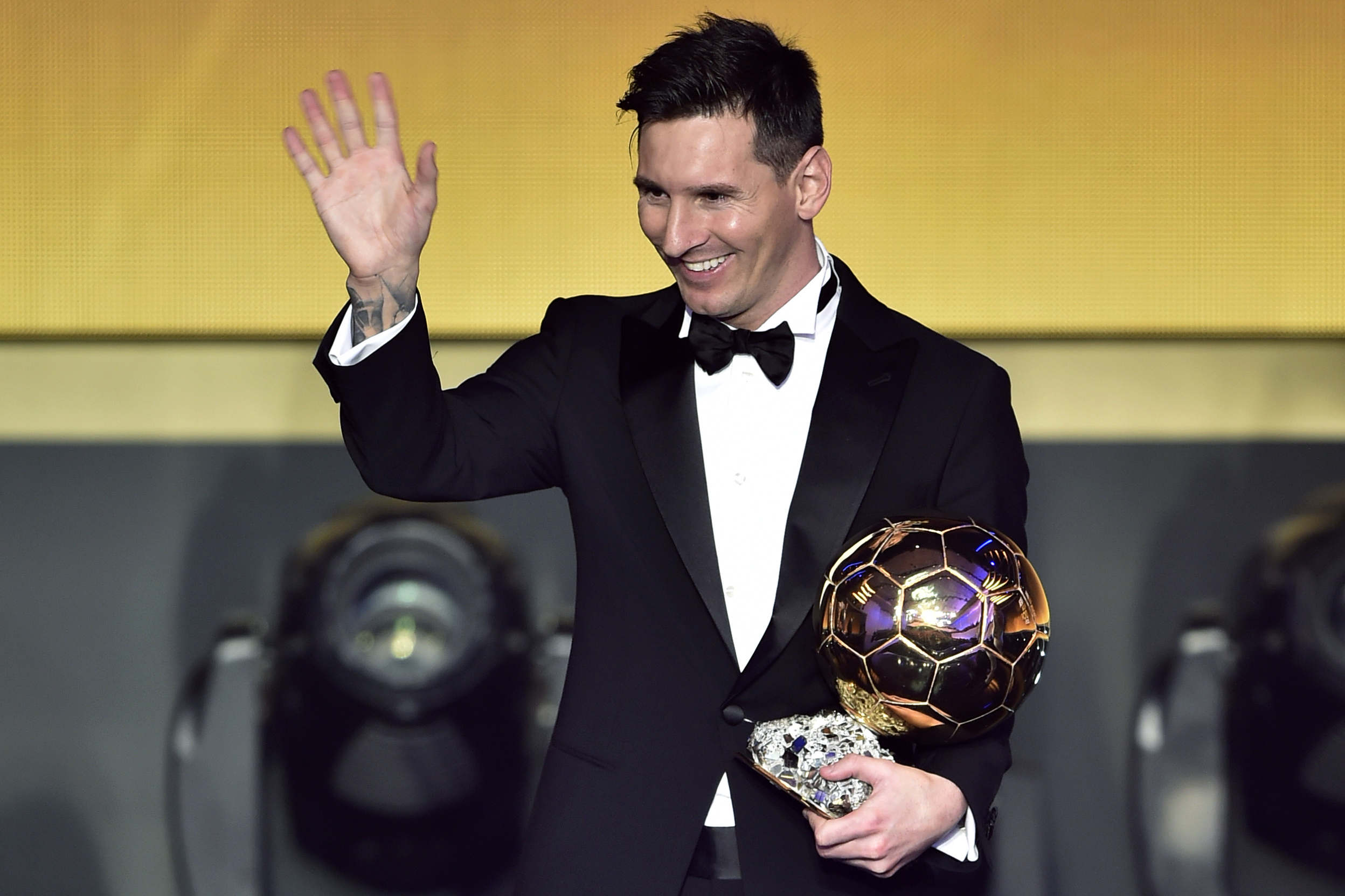Lionel Messi waves holding his trophy after receiving the 2015 FIFA Ballon dOr award for player of the year during the 2015 FIFA Ballon d'Or award ceremony in Zurich on Jan. 11, 2016.